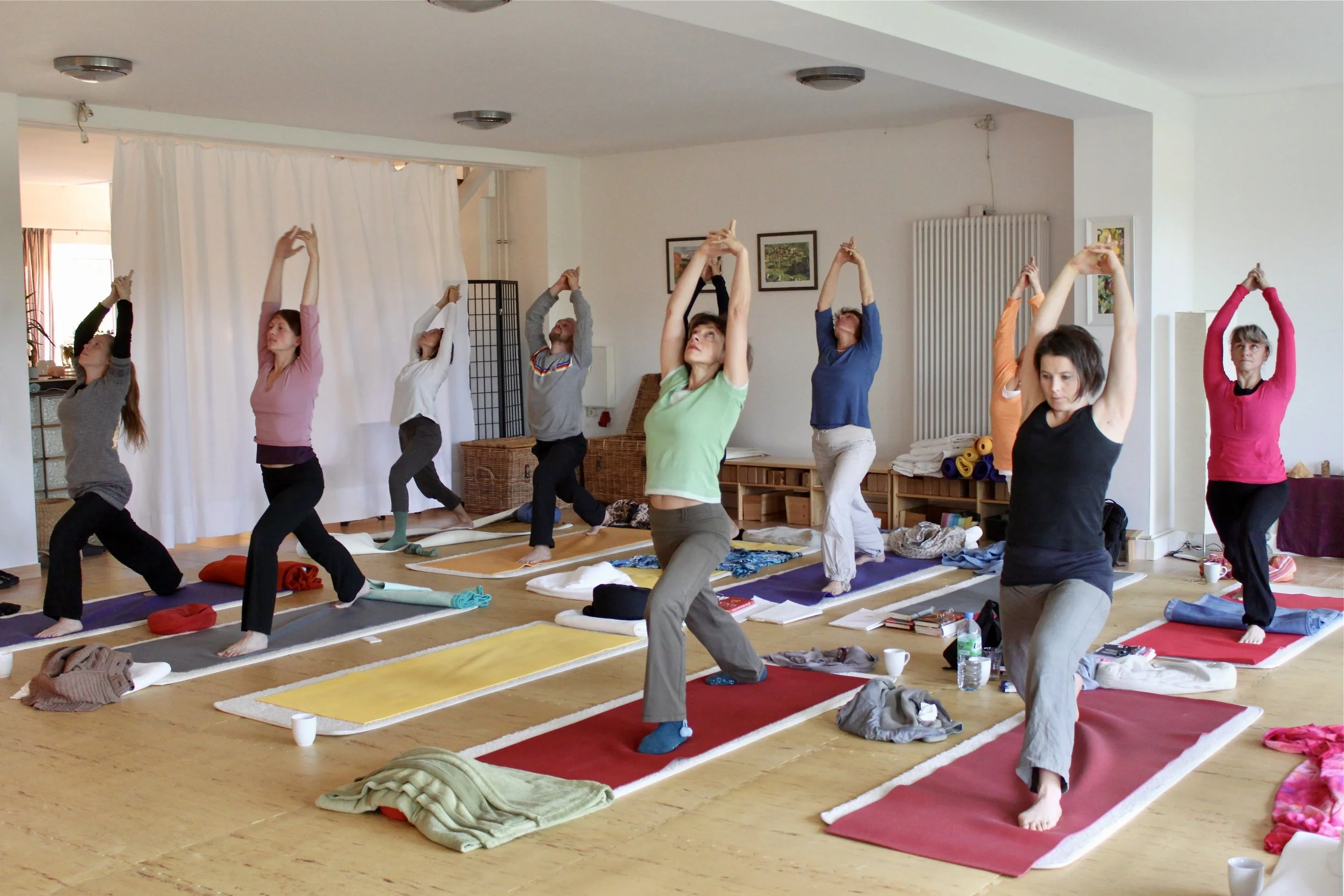 Menschen machen Yoga in einem hellen Raum.