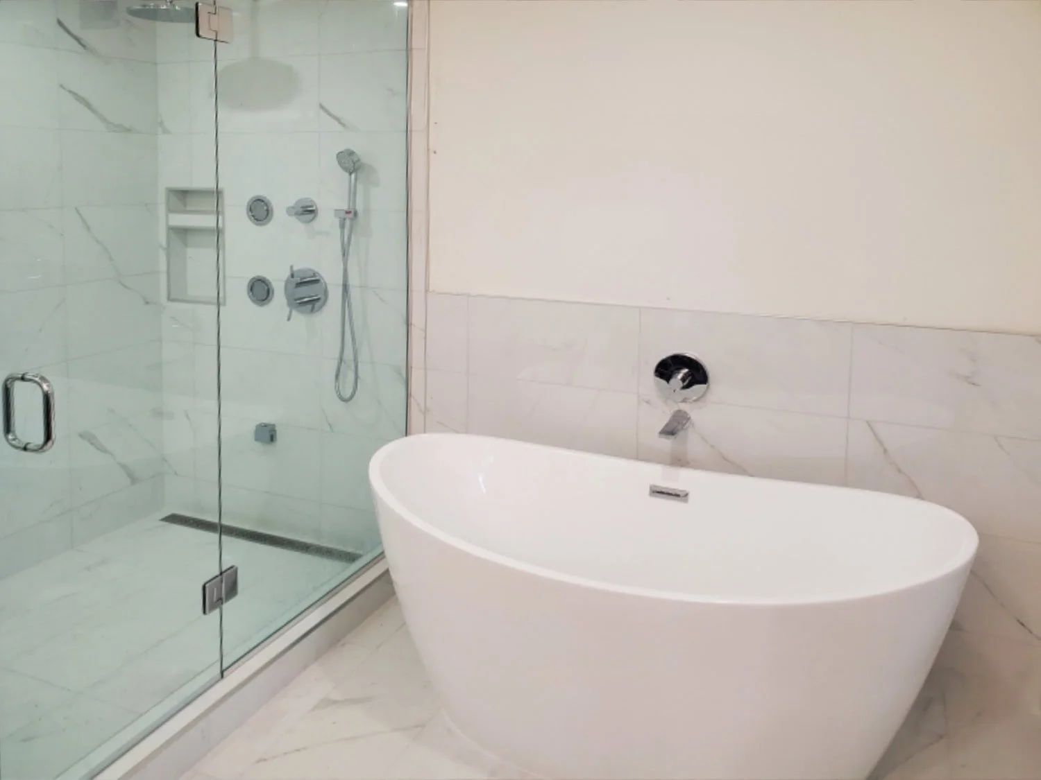 Modern bathroom with a glass-enclosed shower and a standalone white bathtub.
