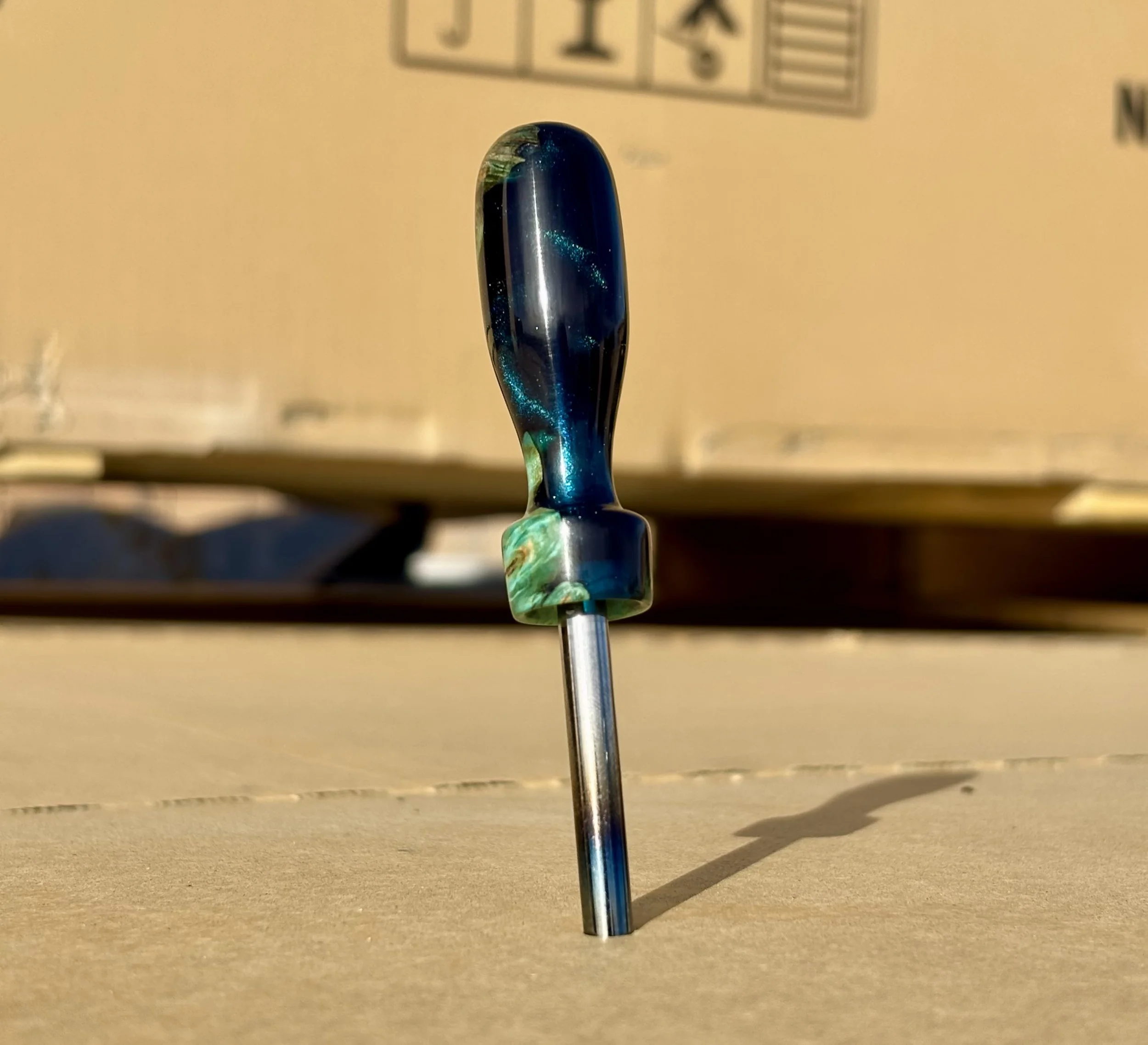 Divot tool for golf made from dyed stabilized maple burl. Single prong made from heat treated steel. Tool is in the shape of a bomb