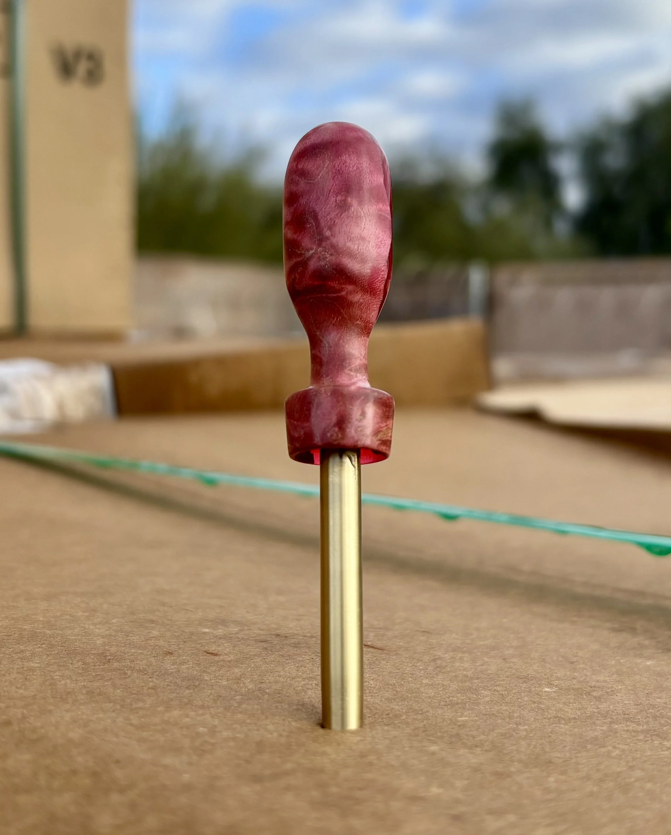 Divot tool for golf made from dyed stabilized maple burl. Single prong made from Brass. Tool is in the shape of a bomb