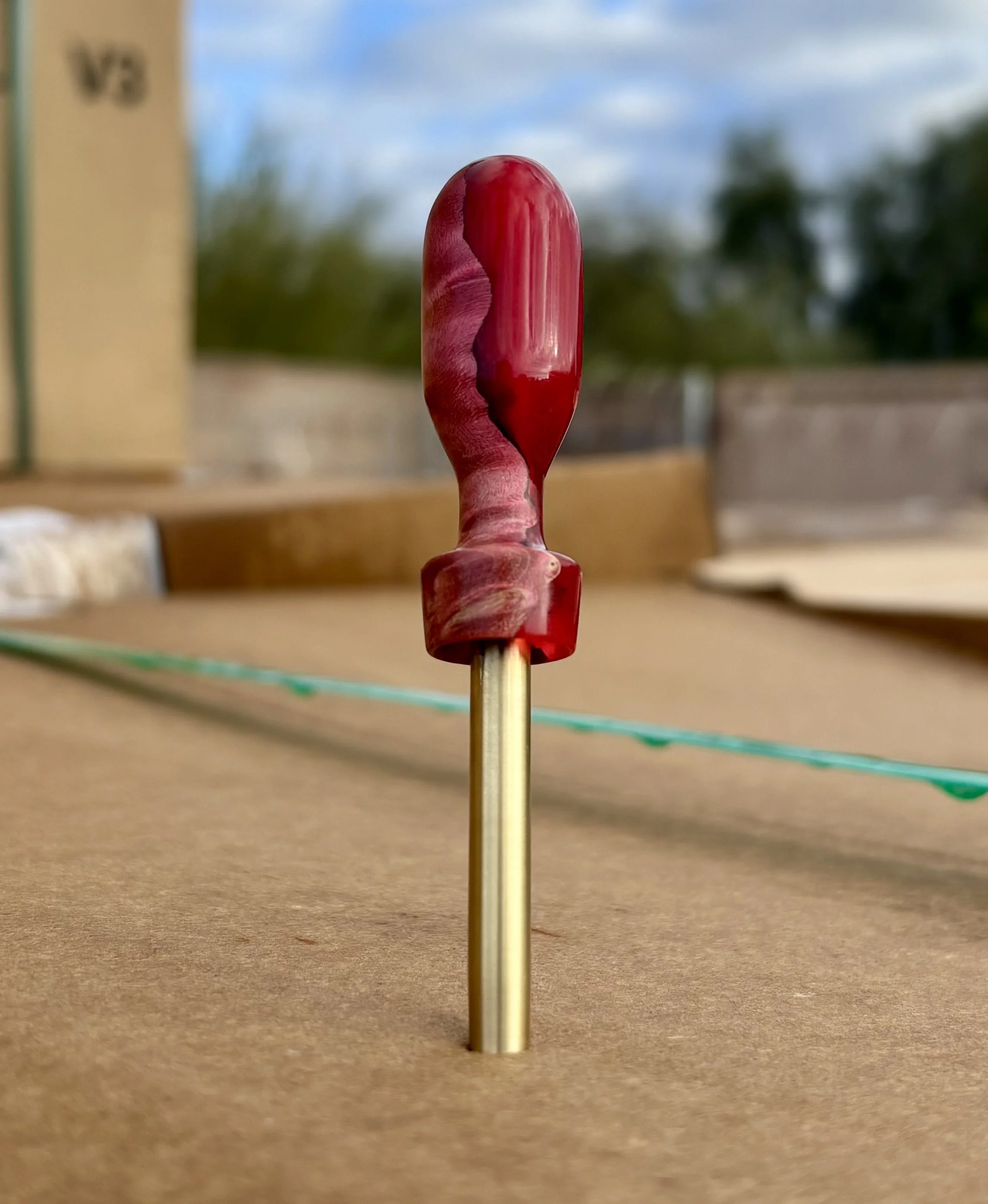 Divot tool for golf made from dyed stabilized maple burl. Single prong made from Brass. Tool is in the shape of a bomb