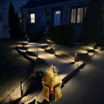 A small, illuminated walkway with a landscape lights installed by Spartan Home Pros