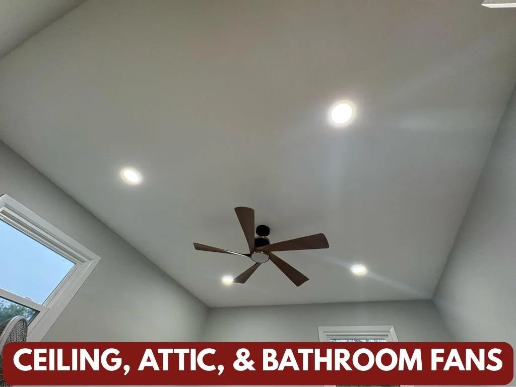 A ceiling with recessed lights, a ceiling fan with brown blades, a window with white trim, and a gray wall with a vent.