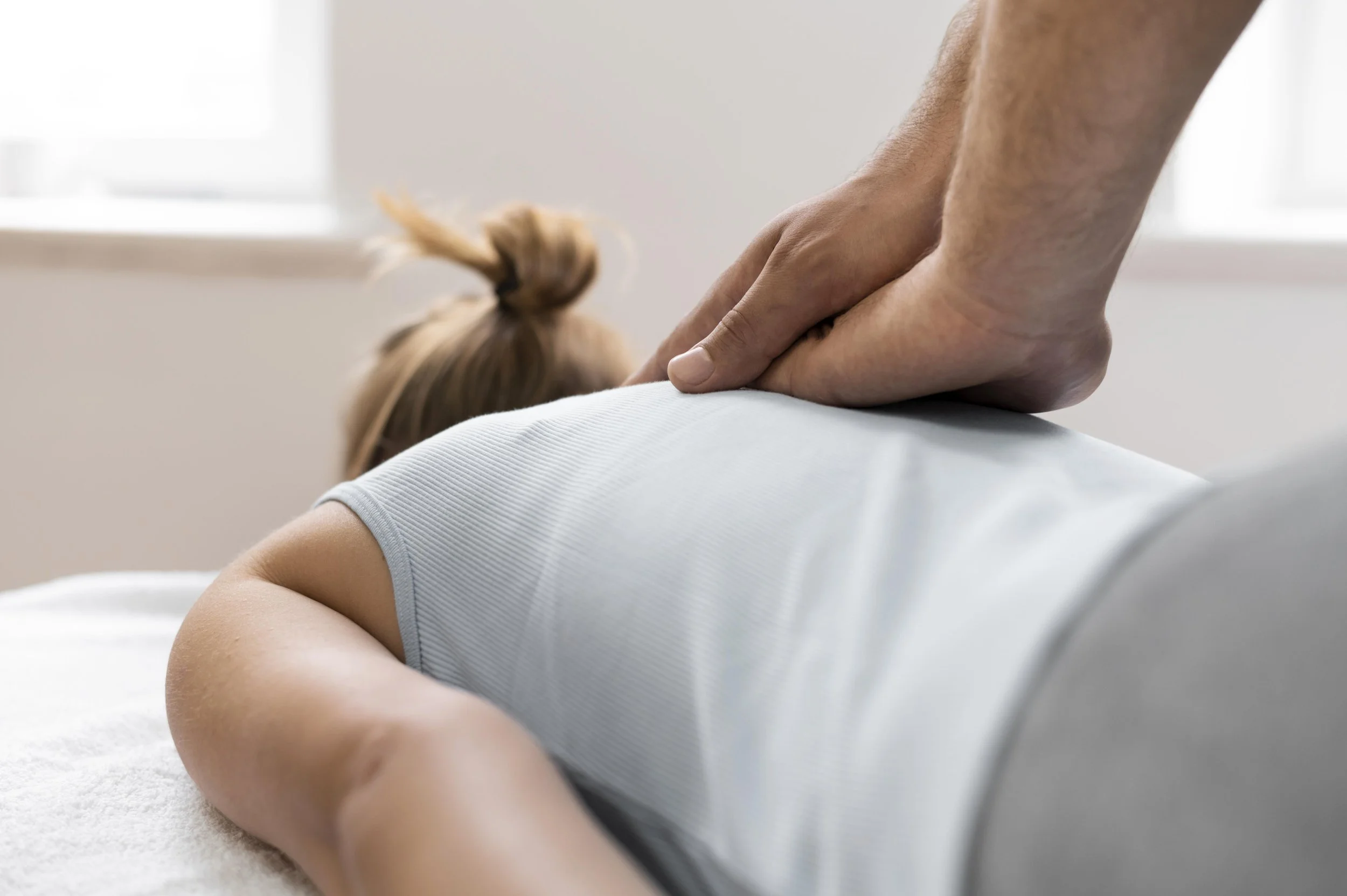 A person receiving a soft tissue work on their back from a chiropractor in a clinic setting.