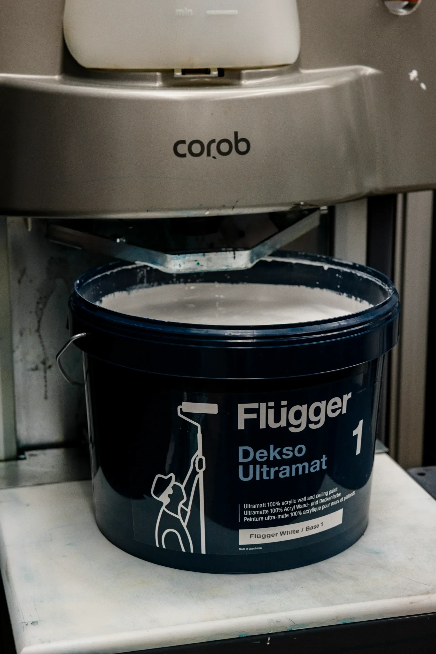 Peinture blanche et base 1 Flügger Ultra-mate, contenant de la peinture à base d'eau ultramat, placé sur une étagère en milieu intérieur.