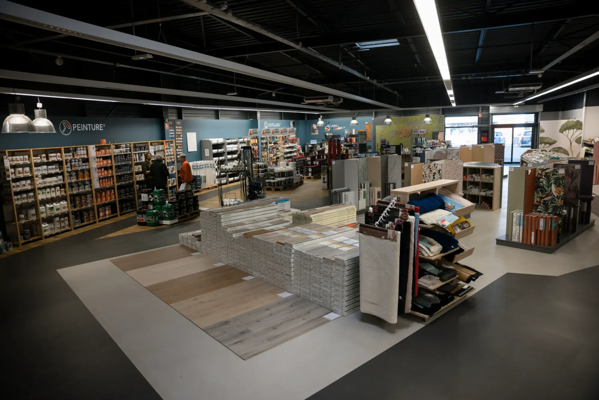 Magasin de bricolage avec rayons de peinture, accessoires de décoration et matériaux de construction.