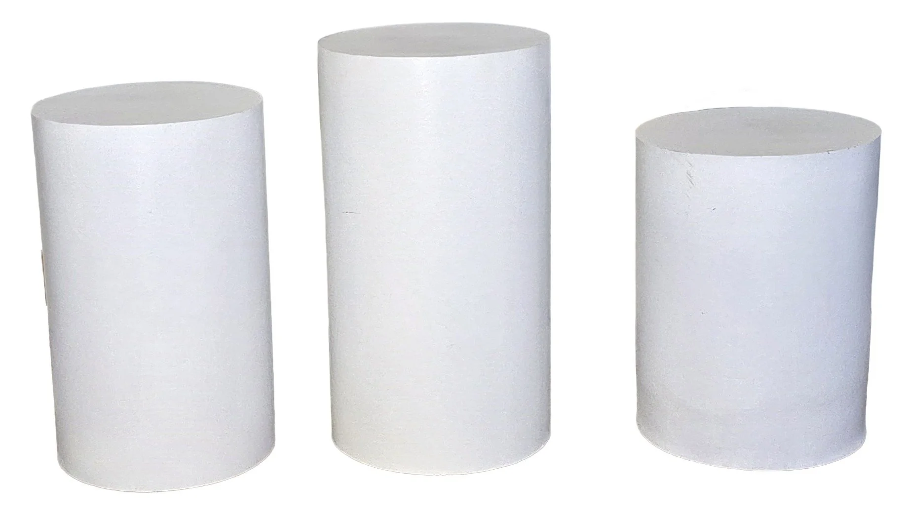 Three white cylindrical foam blocks of varying heights arranged in a row.
