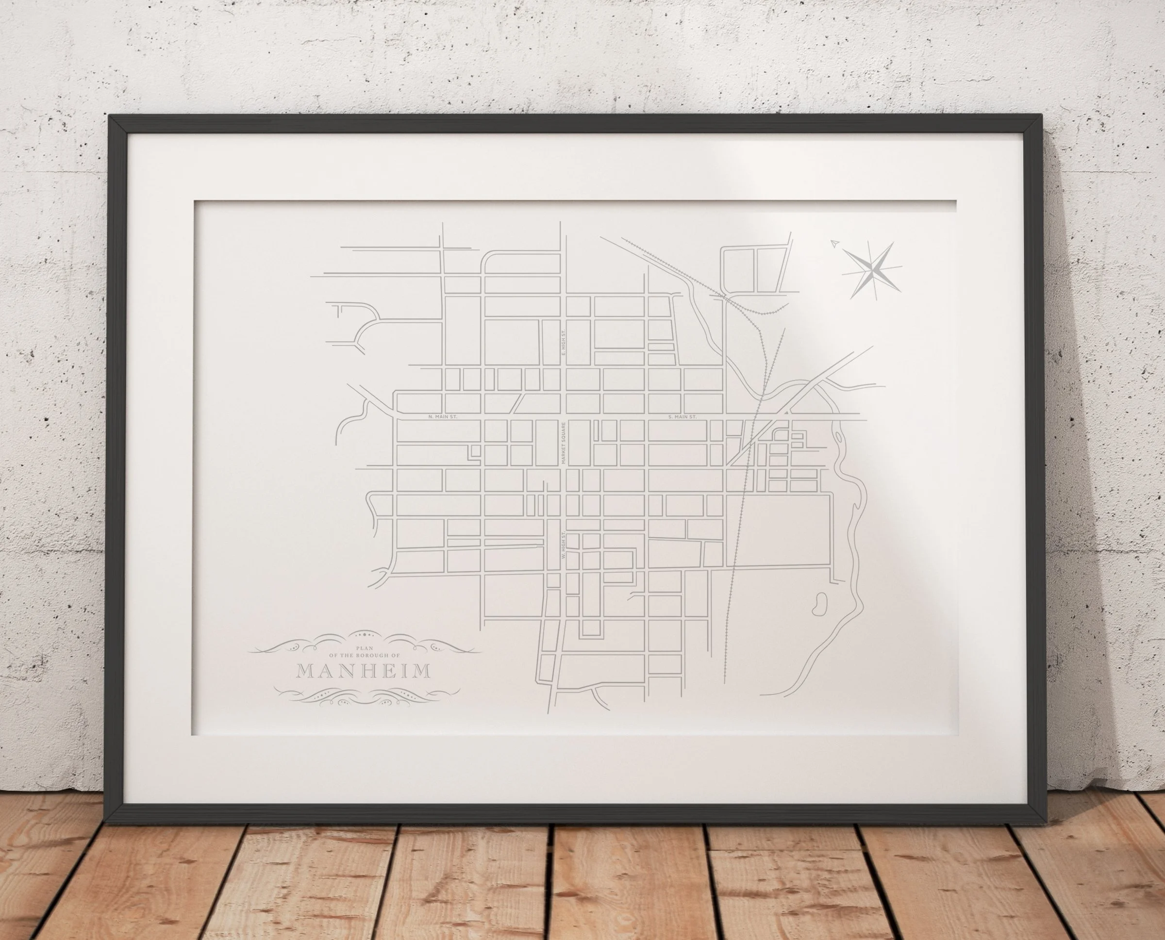 Image of white and gray letterpressed map of Manheim, Pa in a black picture frame.