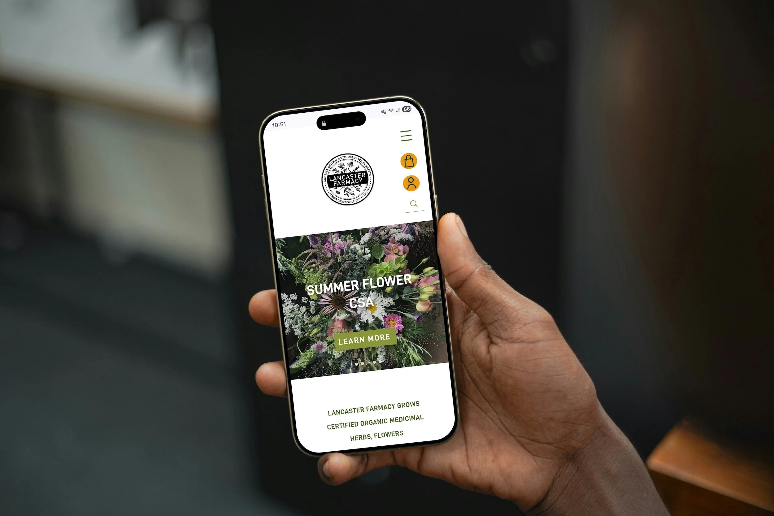 Shows hand holding phone with Lancaster Farmacy's mobile website open on the screen.