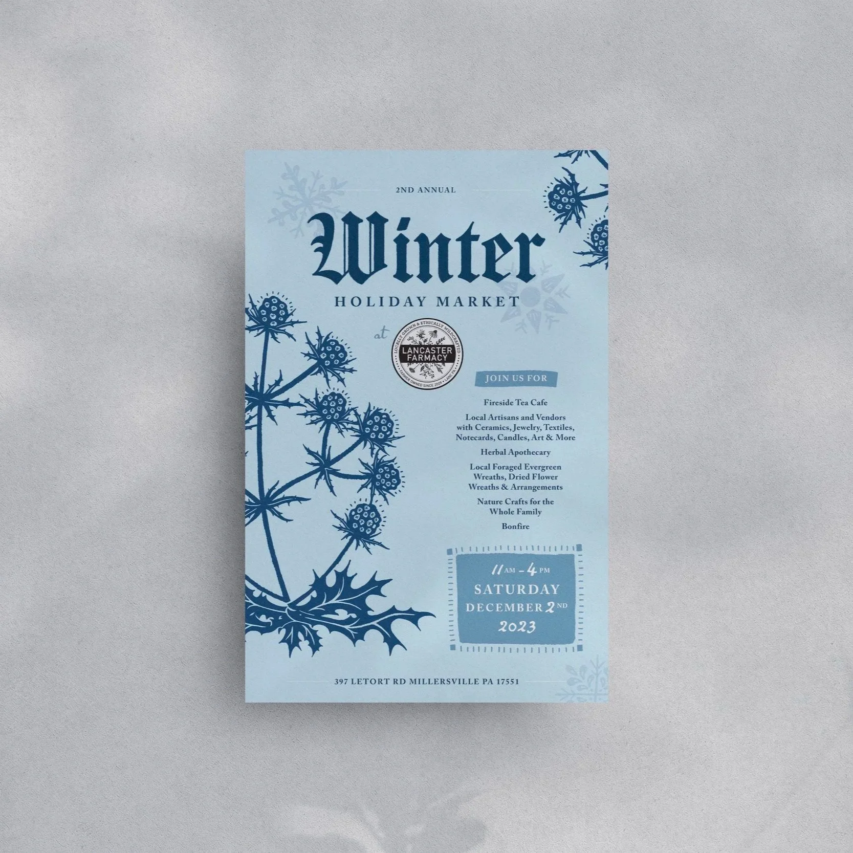 Printed poster on wall with shadows. Winter holiday market poster with a blue background and a vector sea holly flower illustration.