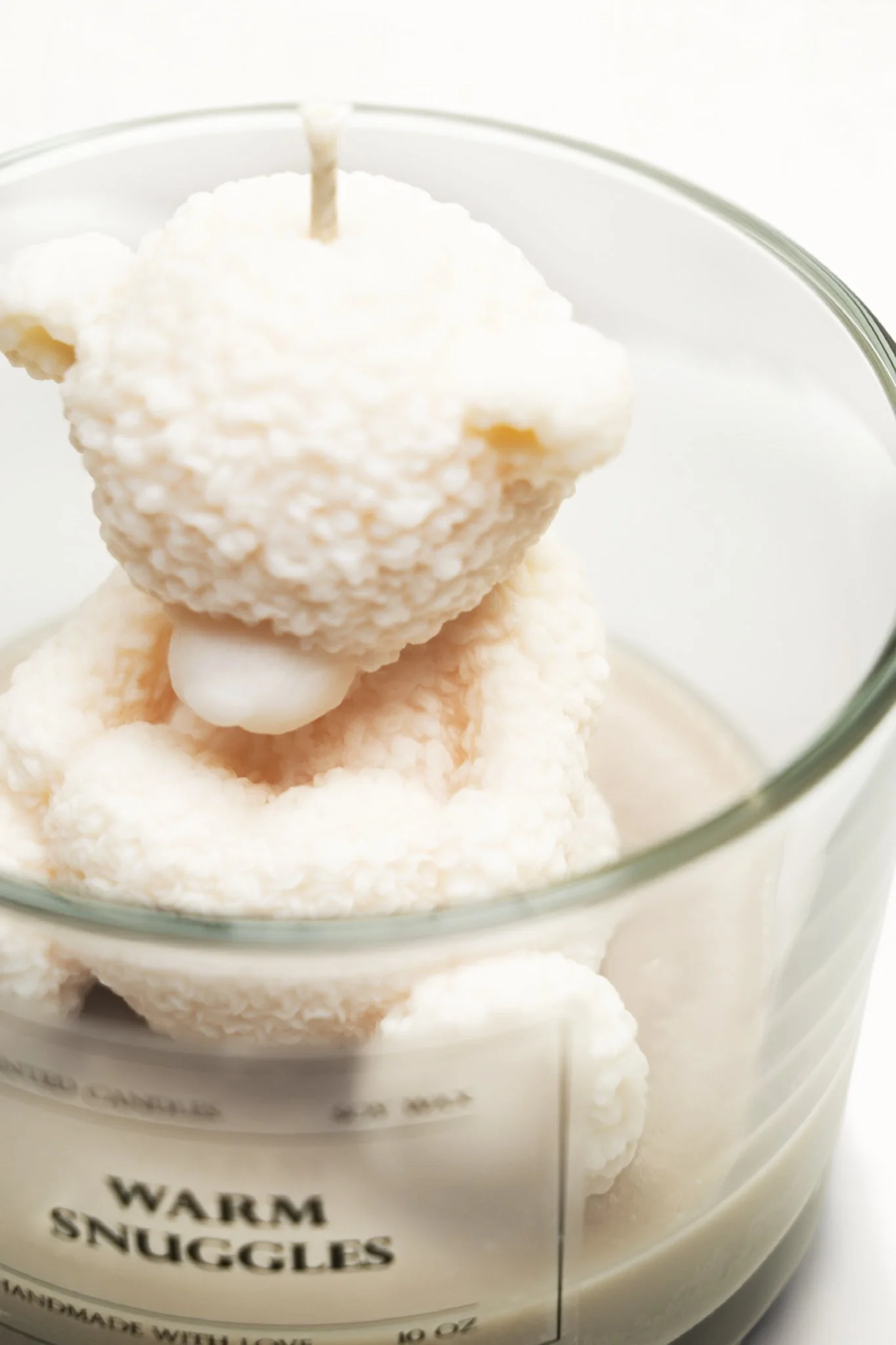 Close-up of a glass jar filled with white coconut-covered marshmallow snack balls labeled "Warm Snuggles."