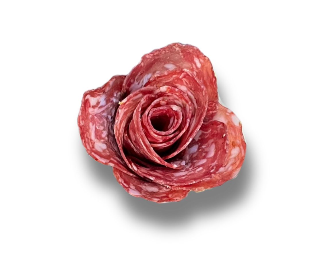 Salami slices arranged in the shape of a rose on a black background.