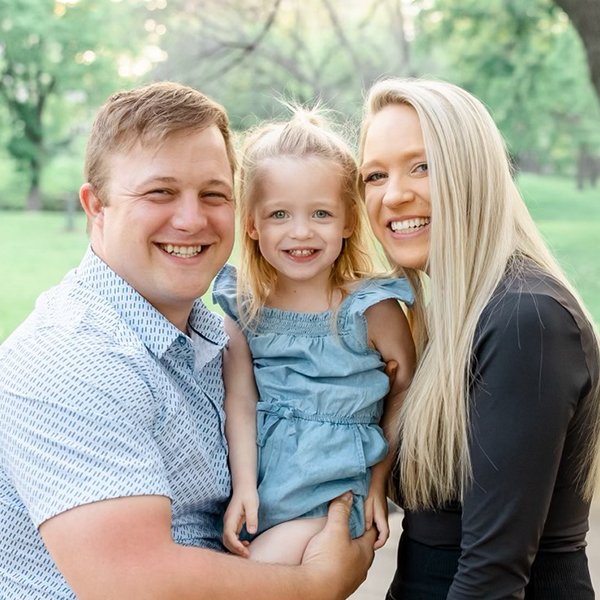 Sawyer and his family with two adults and one child in a park setting.