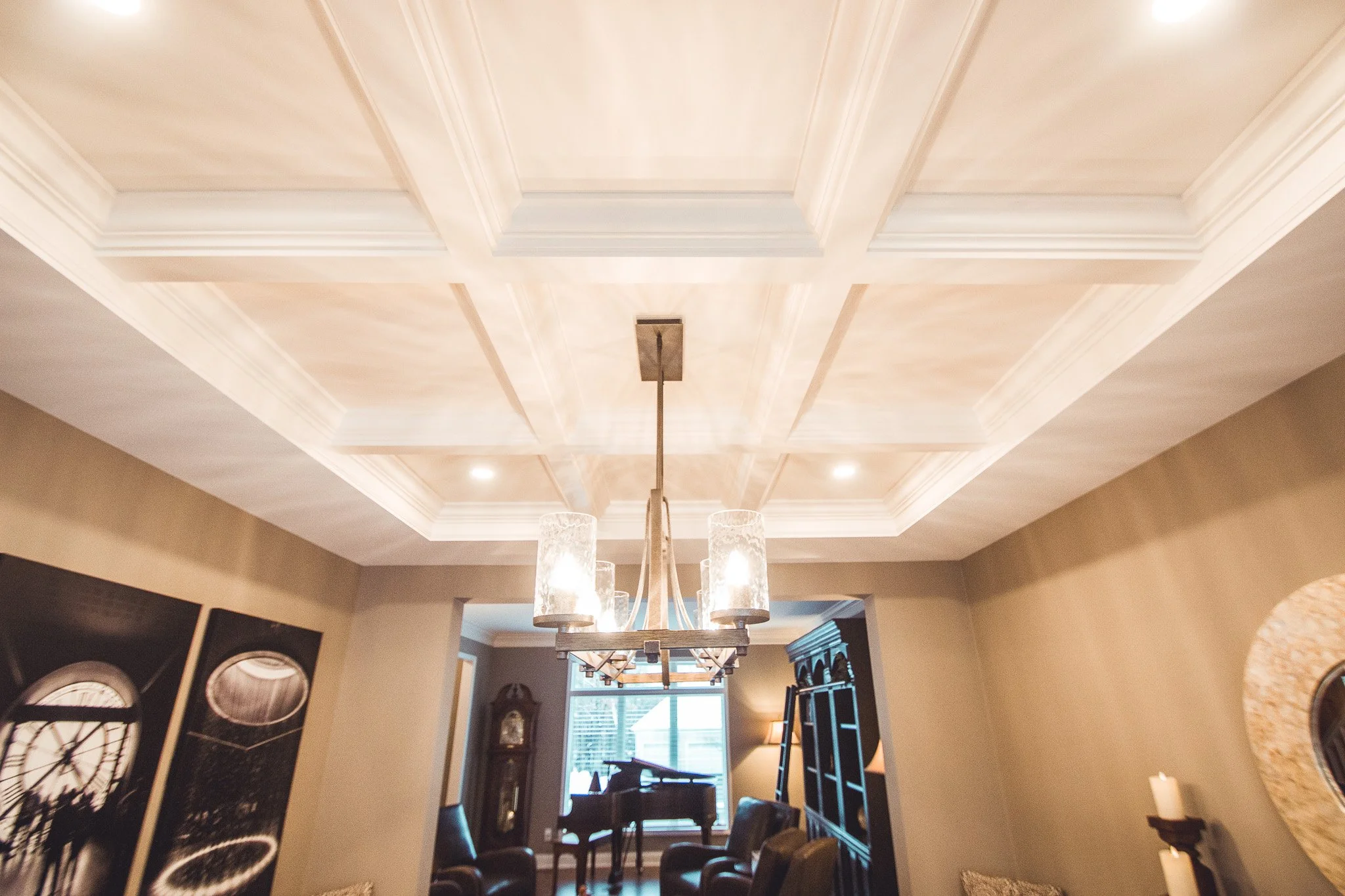 Living room remodel in Eden Prairie with coffered ceiling, a chandelier, and elegant decor including a piano and grandfather clock.