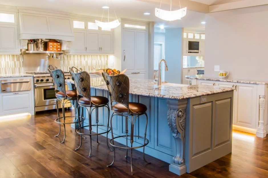 Modern kitchen remodel in Edina with an island and bar stools, featuring stainless steel appliances, granite countertops, and wood flooring.