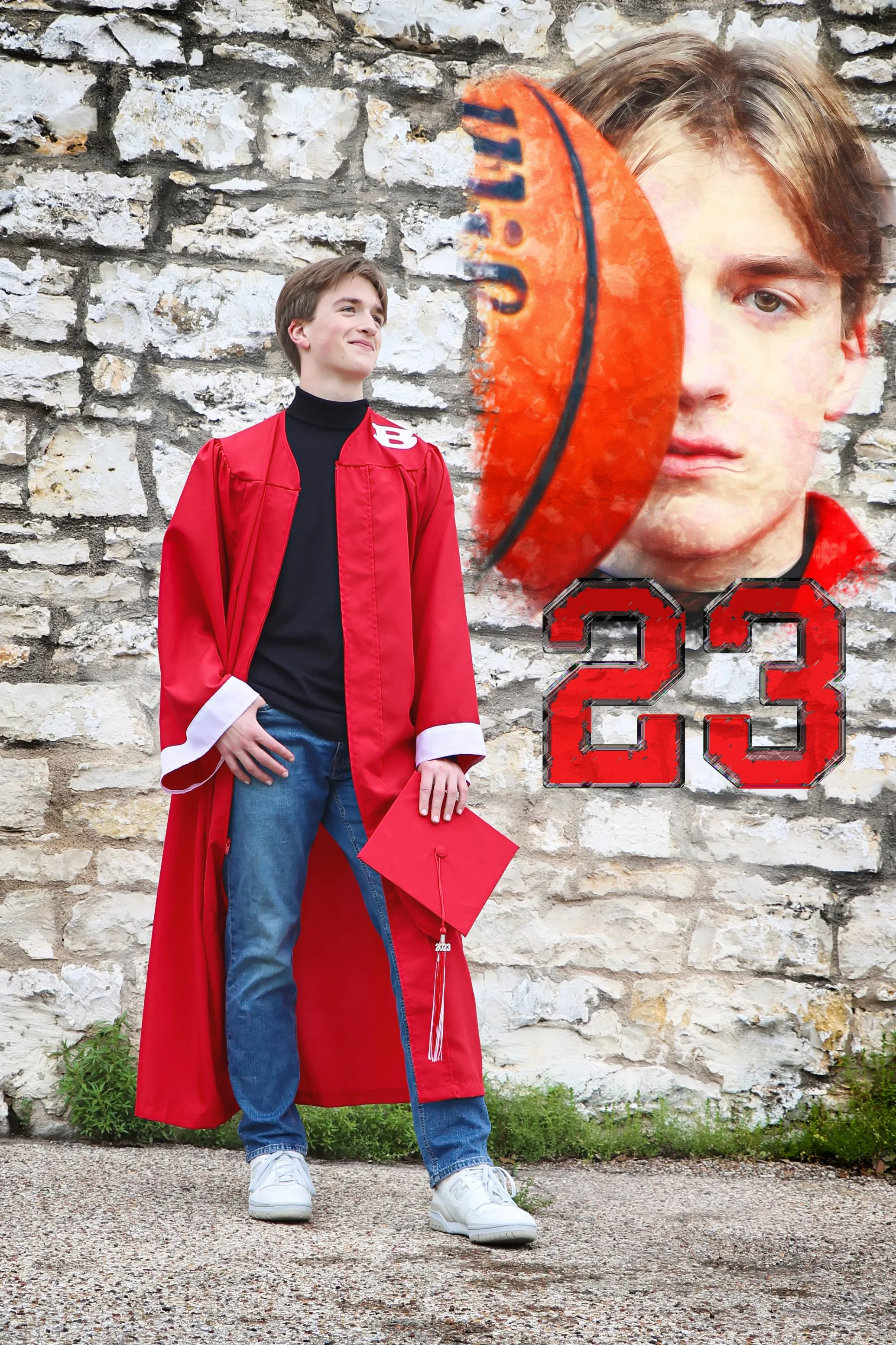 A young man in a red graduation gown and cap posing outdoors against a stone wall, with a large graffiti style mural of his face and the number 23 painted on the wall in Belton, Texas .