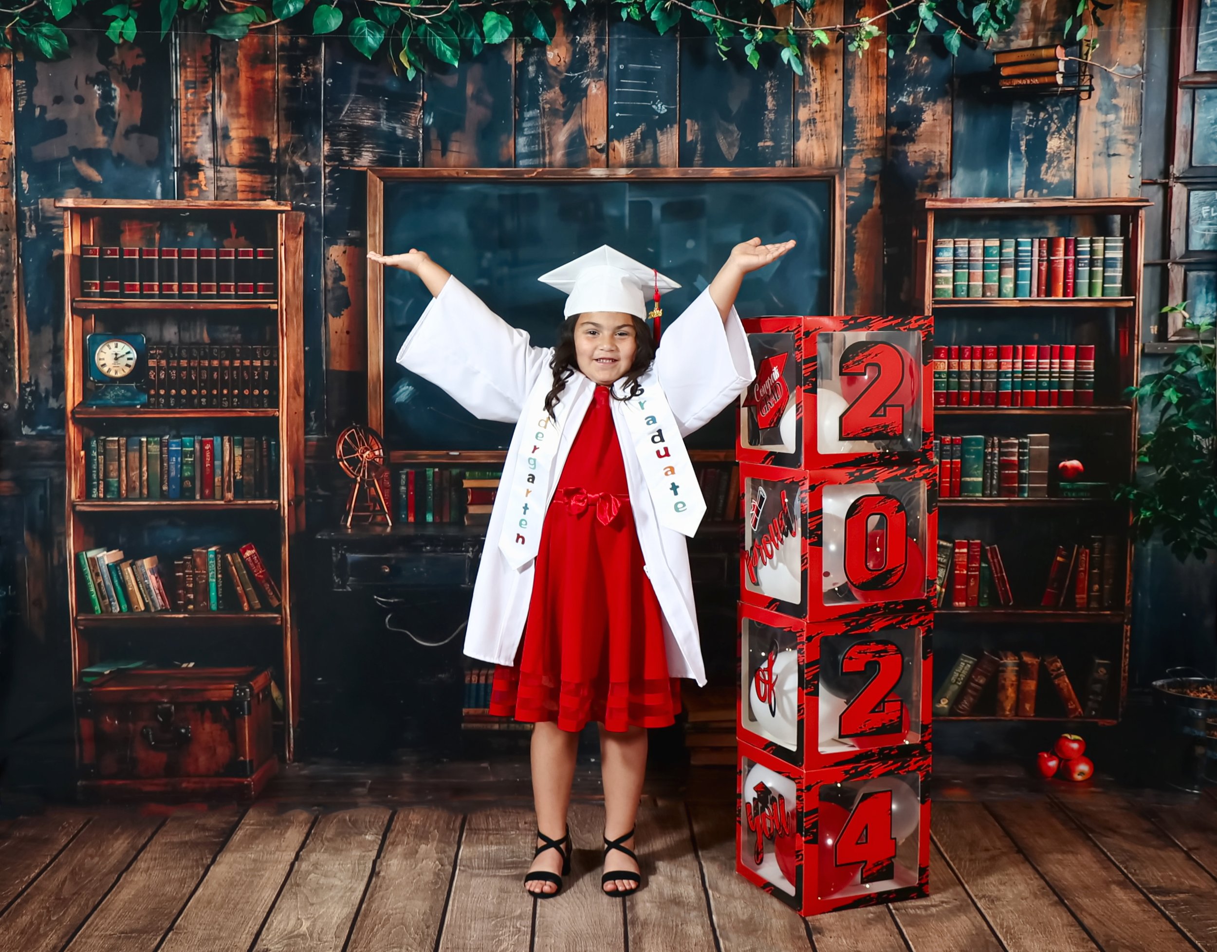 A young girl celebrating her kindergarten graduation with a studio session at Megan Gibson Photography.