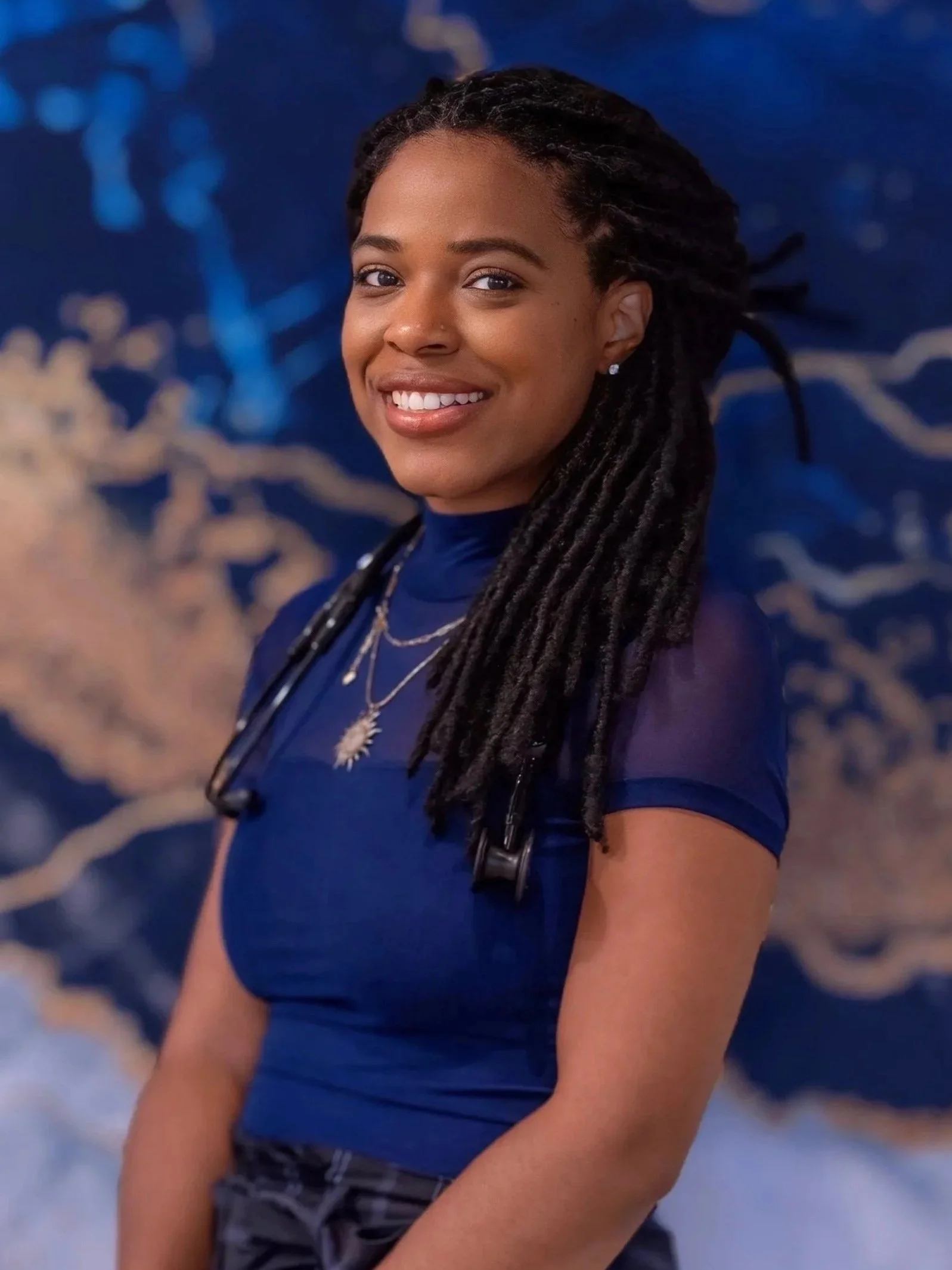 Professional headshot of Brittney Williams, CPM, LM smiling at the camera with a stethoscope.