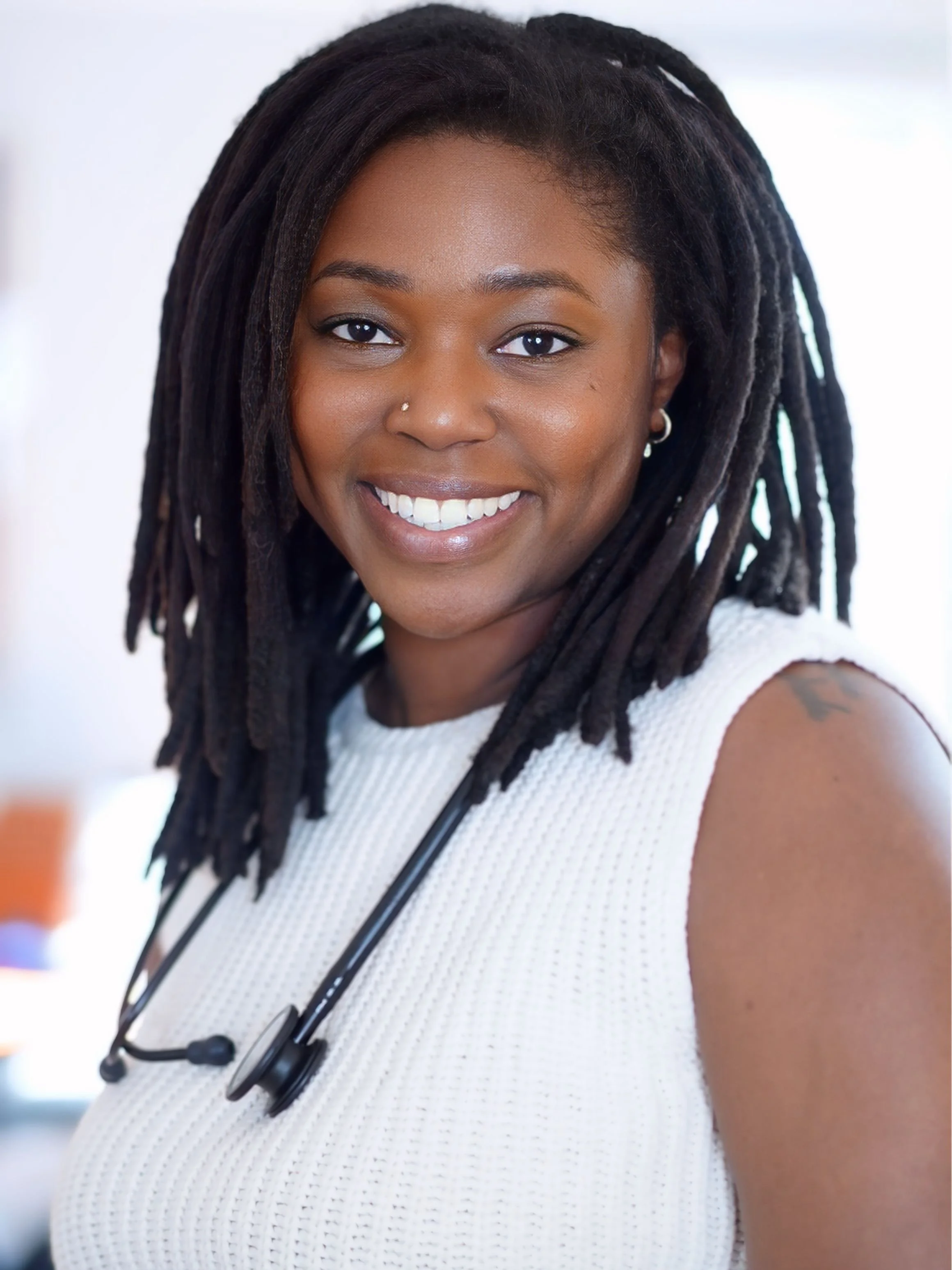 Professional headshot of Ashley Compton, CPM, LM smiling at the camera with a stethoscope.