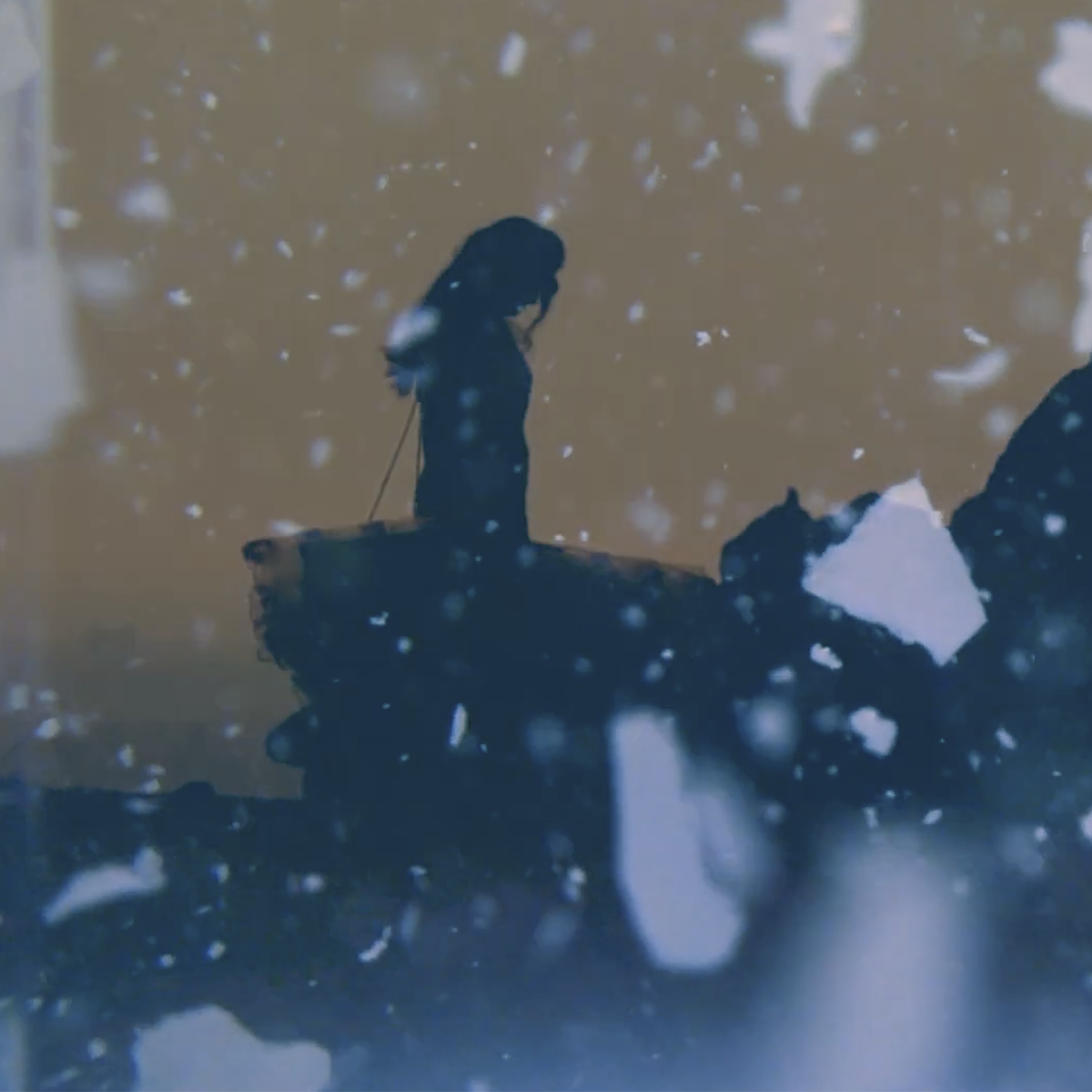 Silhouette of a woman standing on a cliff edge during snowy weather. From a music video by artist, Jesuko.