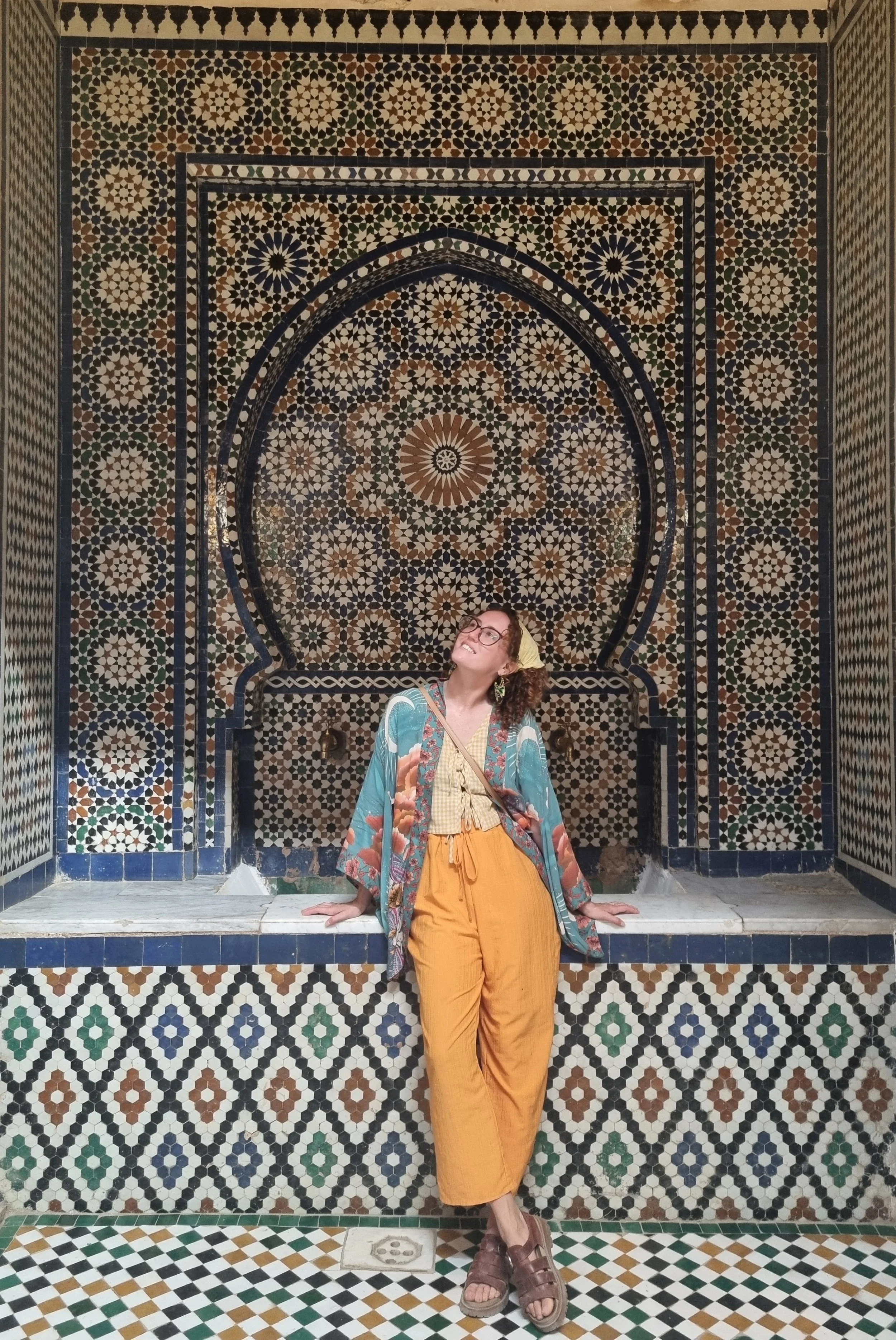 Roxy Henley in front of a mosaic, providing online counselling for women