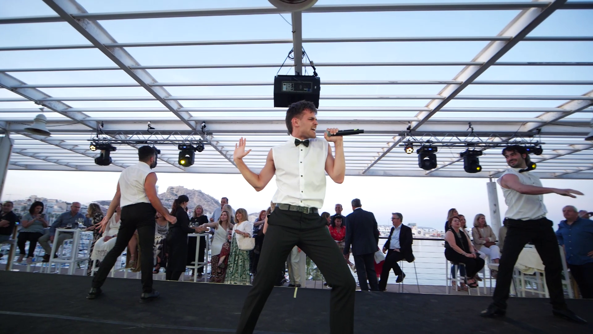 Show corporativo de Cuatr8chos con cantante y bailarines en exterior, formato dinner show para cena de empresa.

