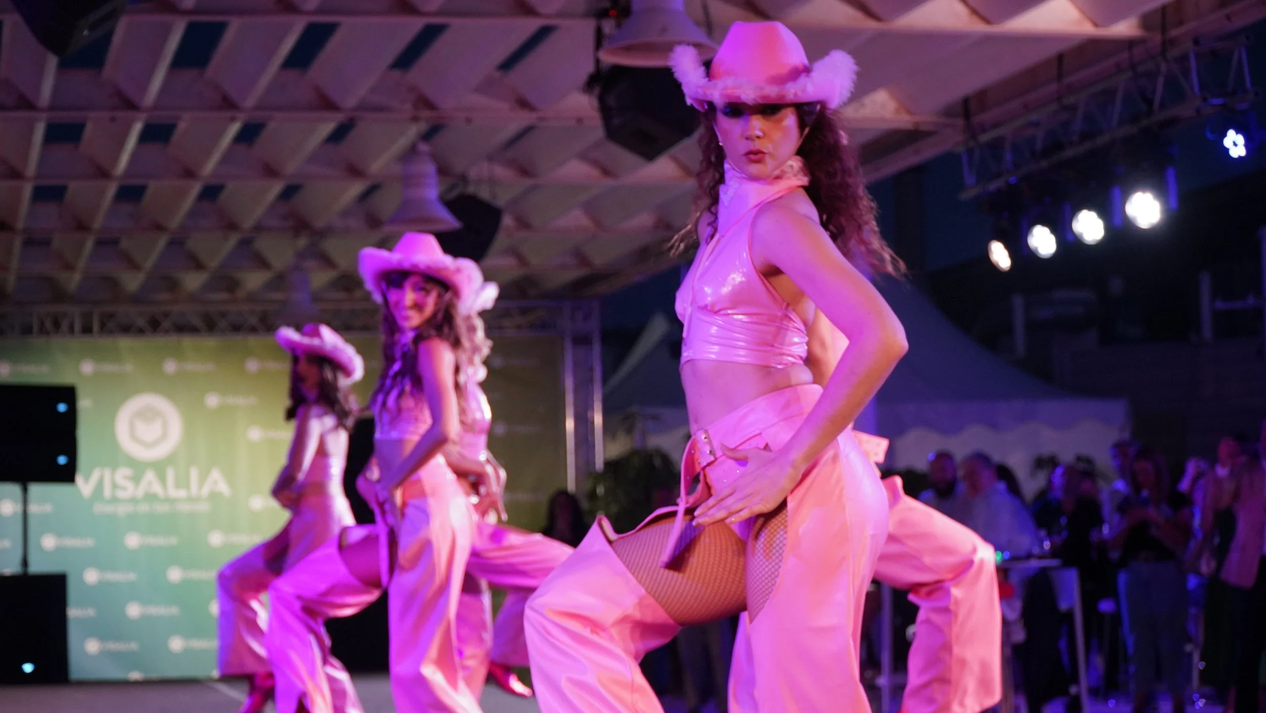 Grupo de bailarinas de Cuatr8chos en show temático con vestuario rosa y estética vaquera, creado para generar impacto visual y energía festiva en eventos.