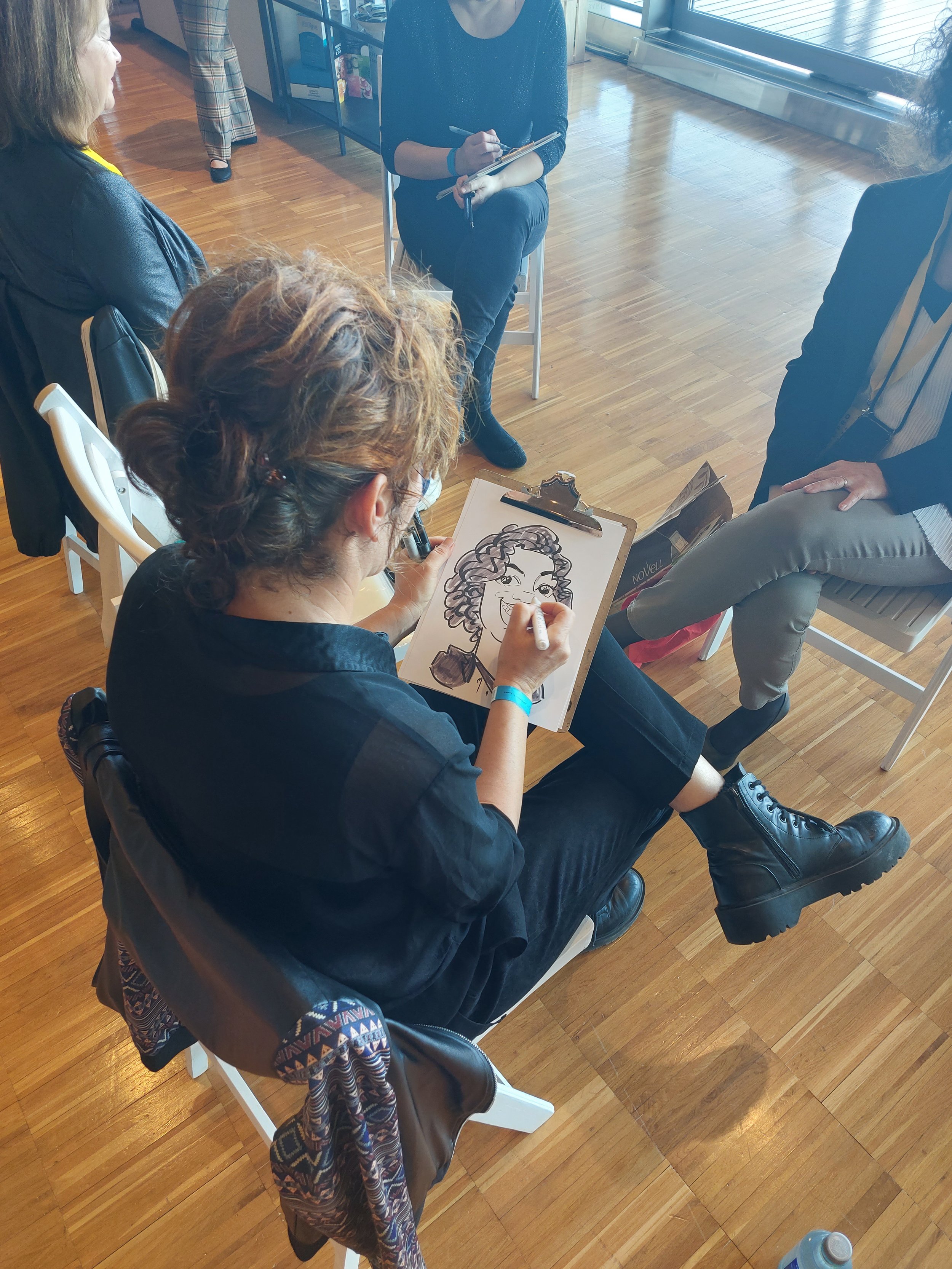 Caricaturista realizando retratos en directo durante un evento corporativo, interactuando con los invitados como acción de animación y entretenimiento.