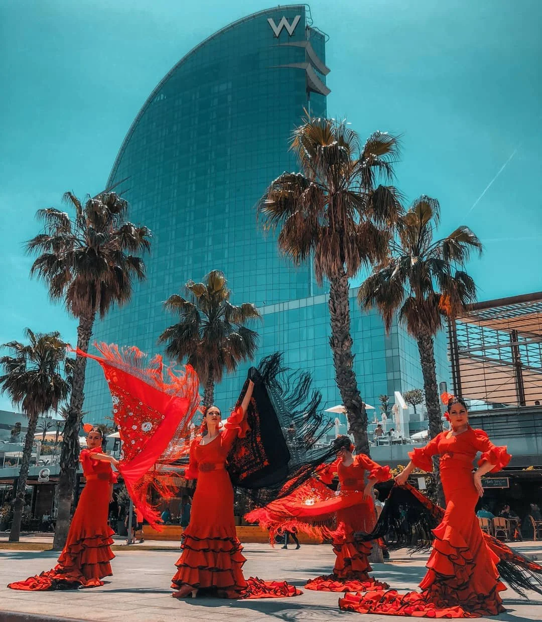 Show de flamenco contemporáneo de Cuatr8chos con bailarinas y abanicos, en un evento exterior con estética urbana y palmeras.