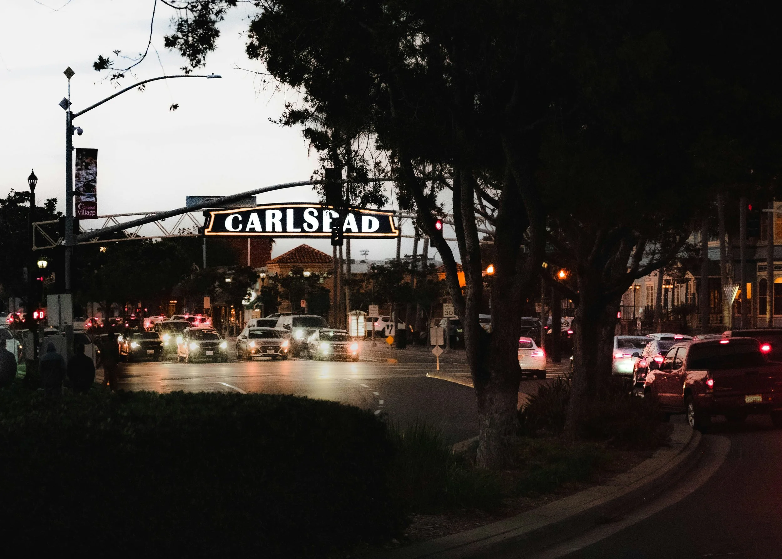 Downtown carlsbad village sign at night representing local upper cervical chiropractic care in Carlsbad, CA