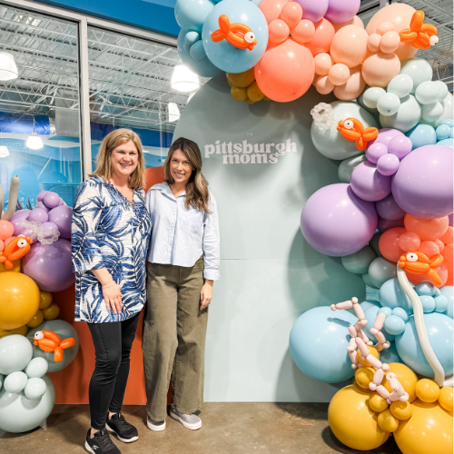 The Pittsburgh Moms owners standing in front of balloons