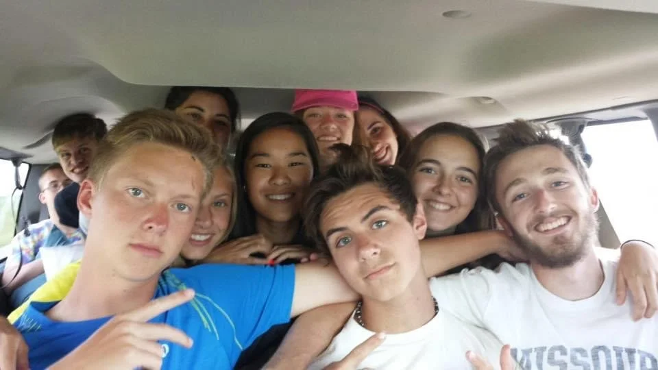 Group of teenagers taking a selfie inside a vehicle.