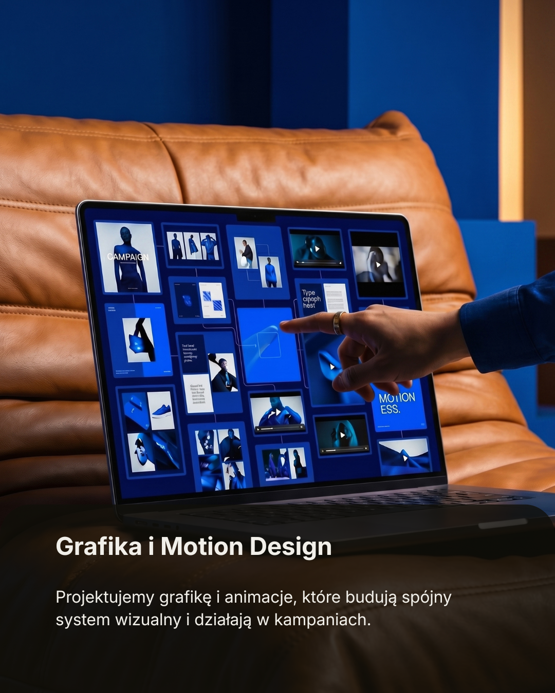 A person is working on a laptop with a screen displaying graphic design and motion graphics elements, while sitting on a brown leather couch against a blue wall.