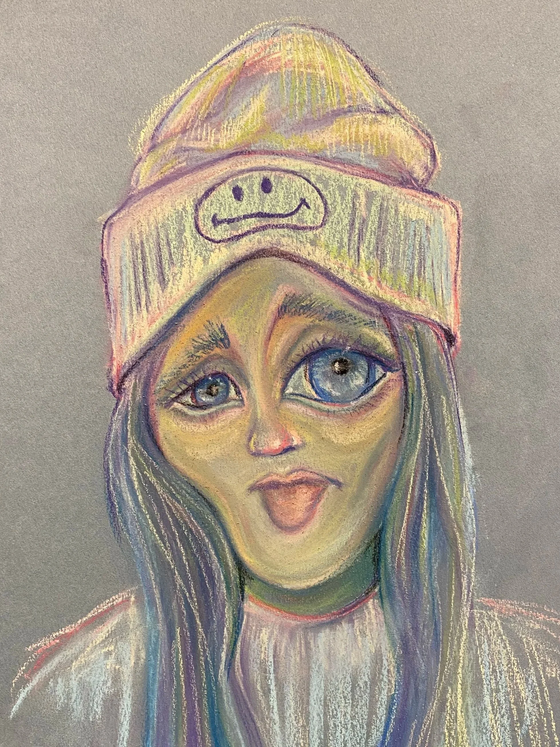 Colorful pastel drawing of a woman with large blue eyes, long hair, wearing a beanie hat with a smiley face on it, on gray background.