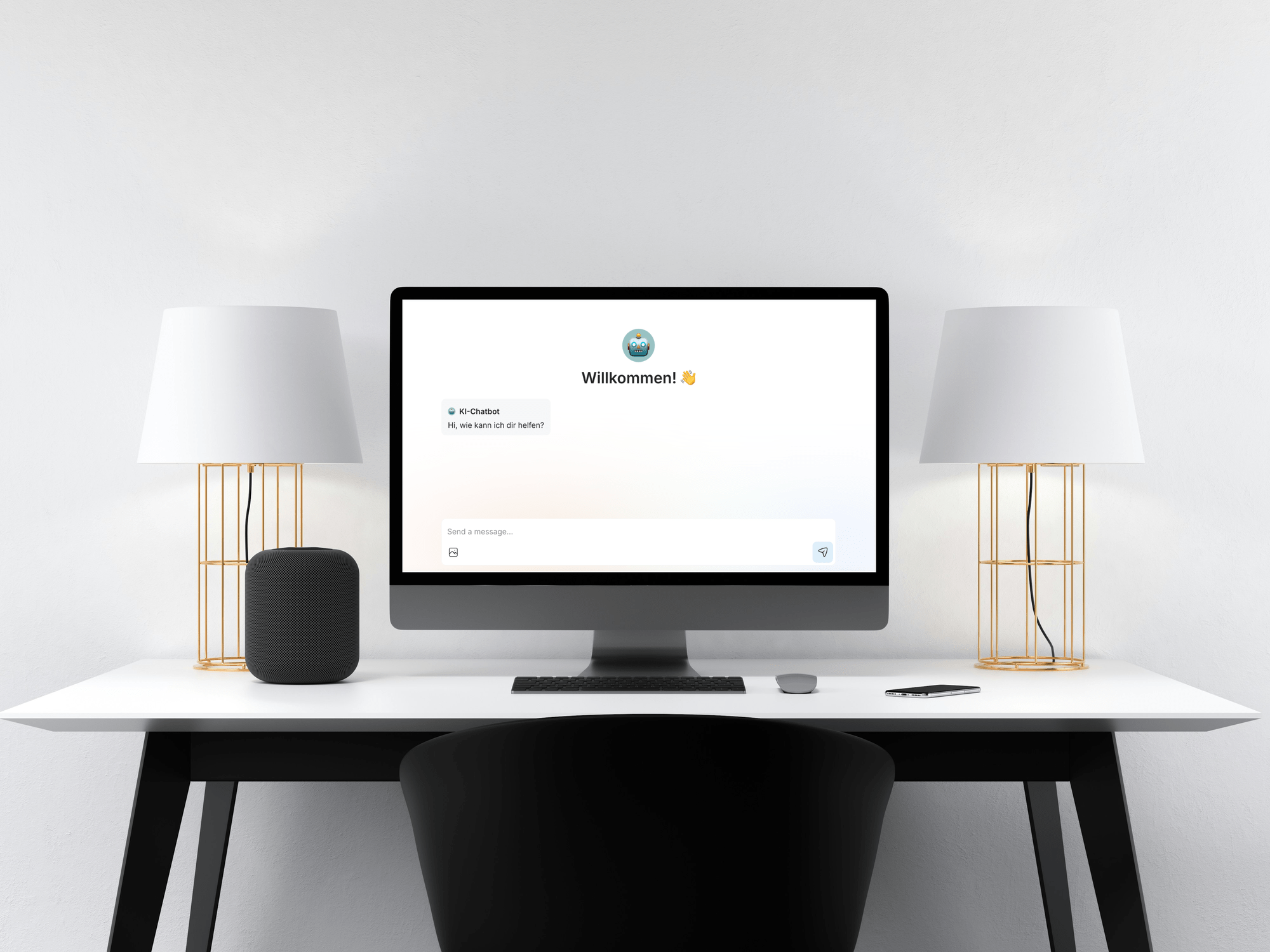 Ein Schreibtisch mit einem Computerbildschirm, der eine Willkommensnachricht und einen Chatbot zeigt, zwei weißen Lampen mit goldenen Gestellen, ein schwarzes Gerät, eine Tastatur, eine Maus und ein Smartphone, alles vor einem weißen Wandhintergrund.