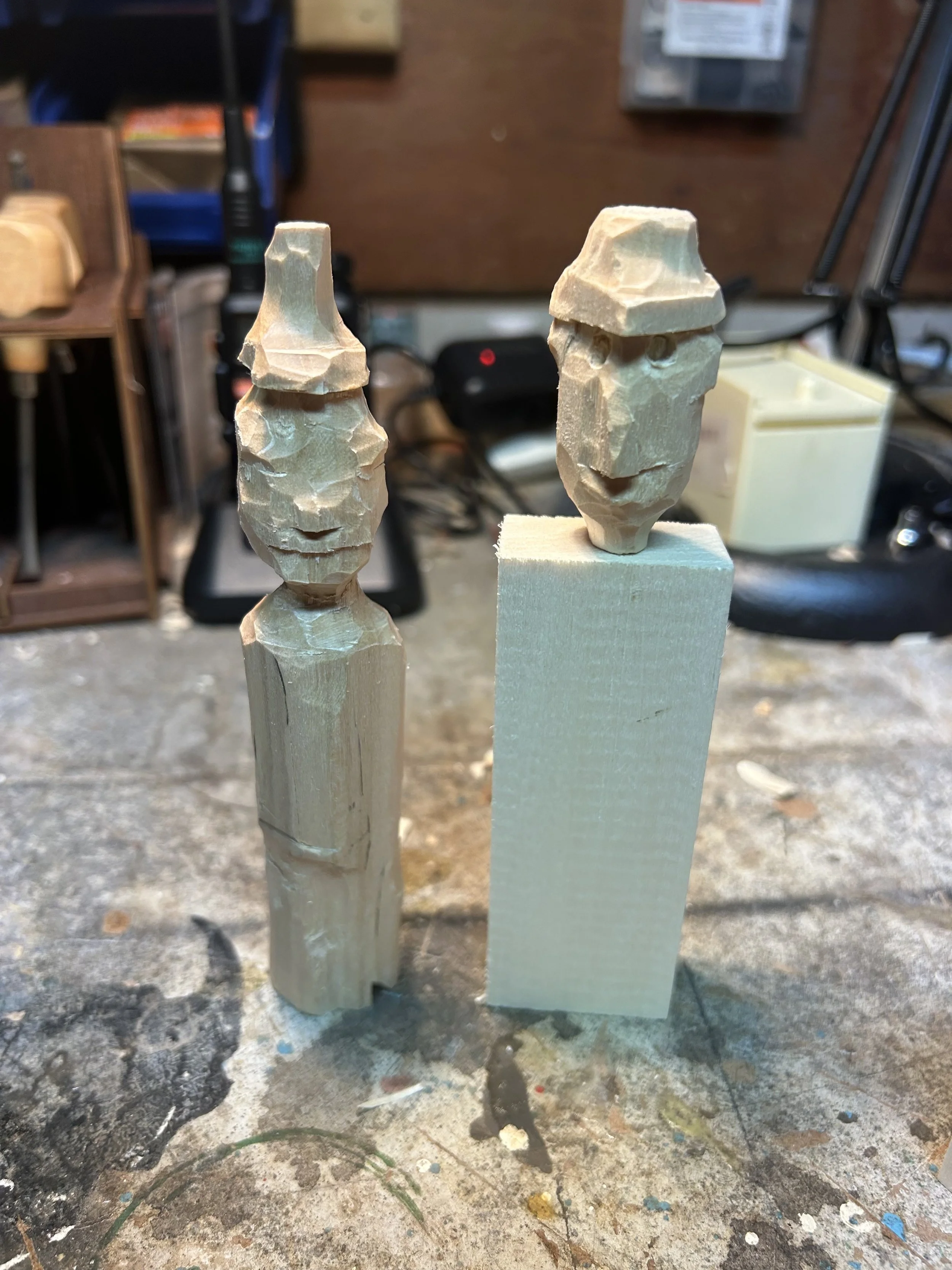 Two in-progress woodcarving figures
