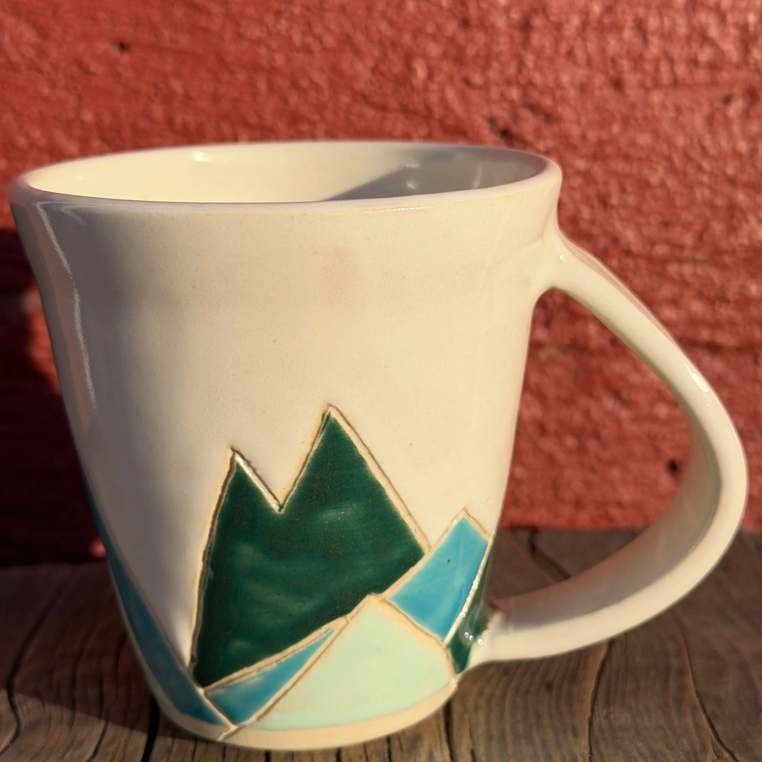 Handmade wheel thrown multi colored mountains on white clay mug modern design stoneware