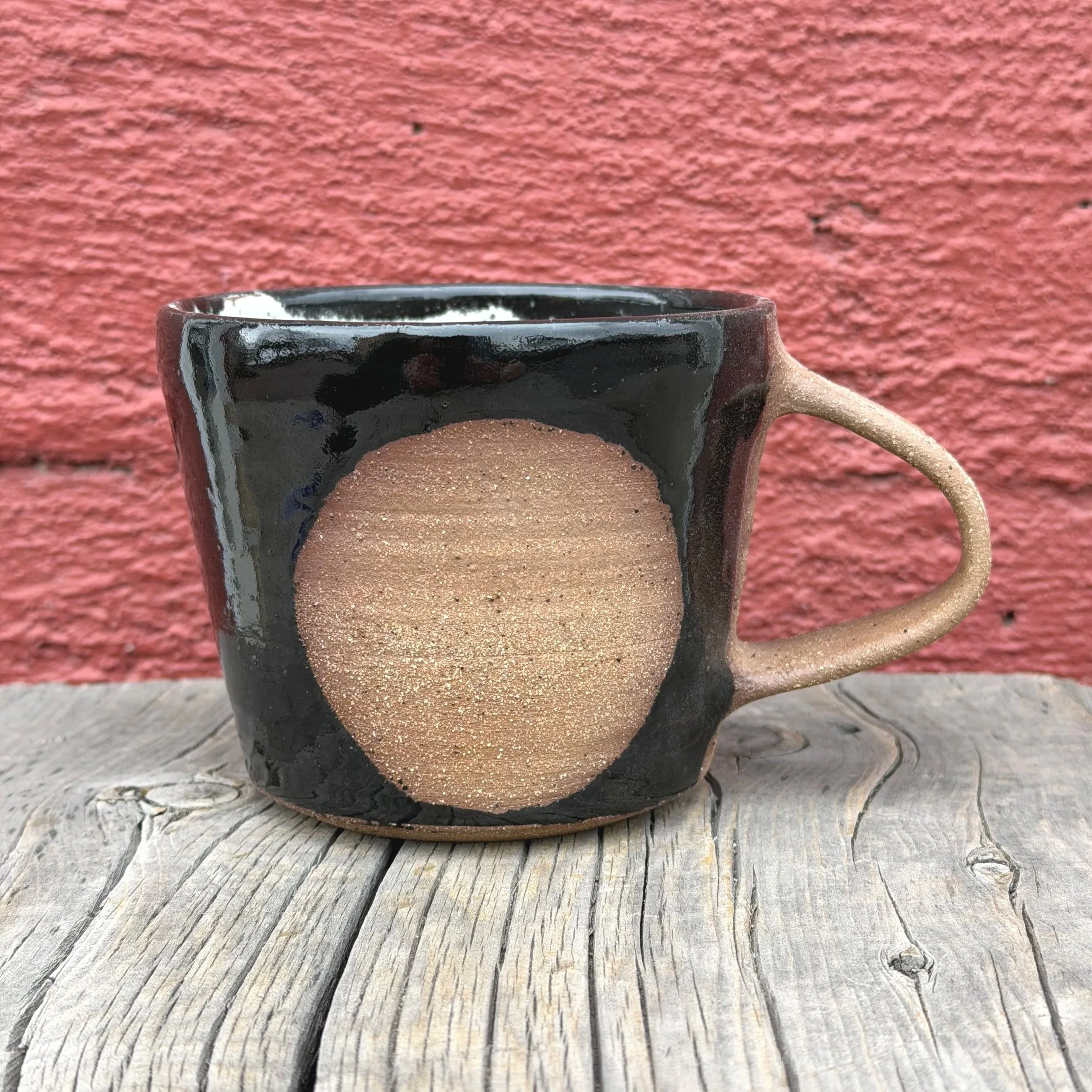 Handmade wheel thrown black gloss glaze with circle on brown clay with speckles mug modern design stoneware mid century modern