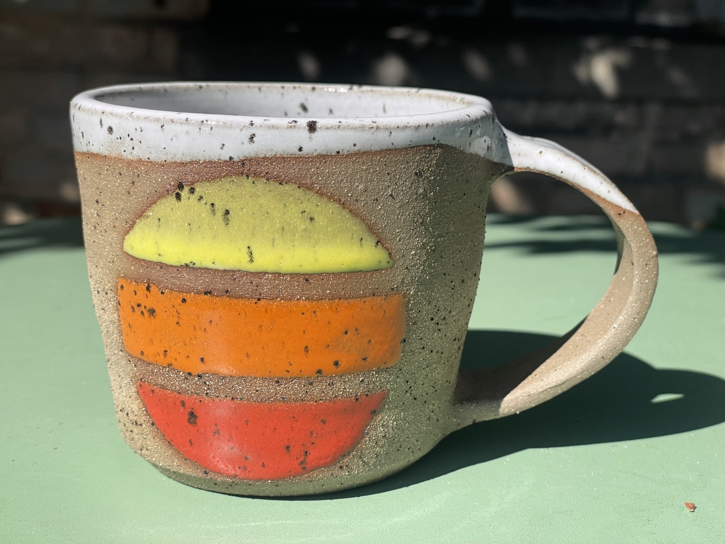 Handmade multi-color circle mug in brown speckled clay