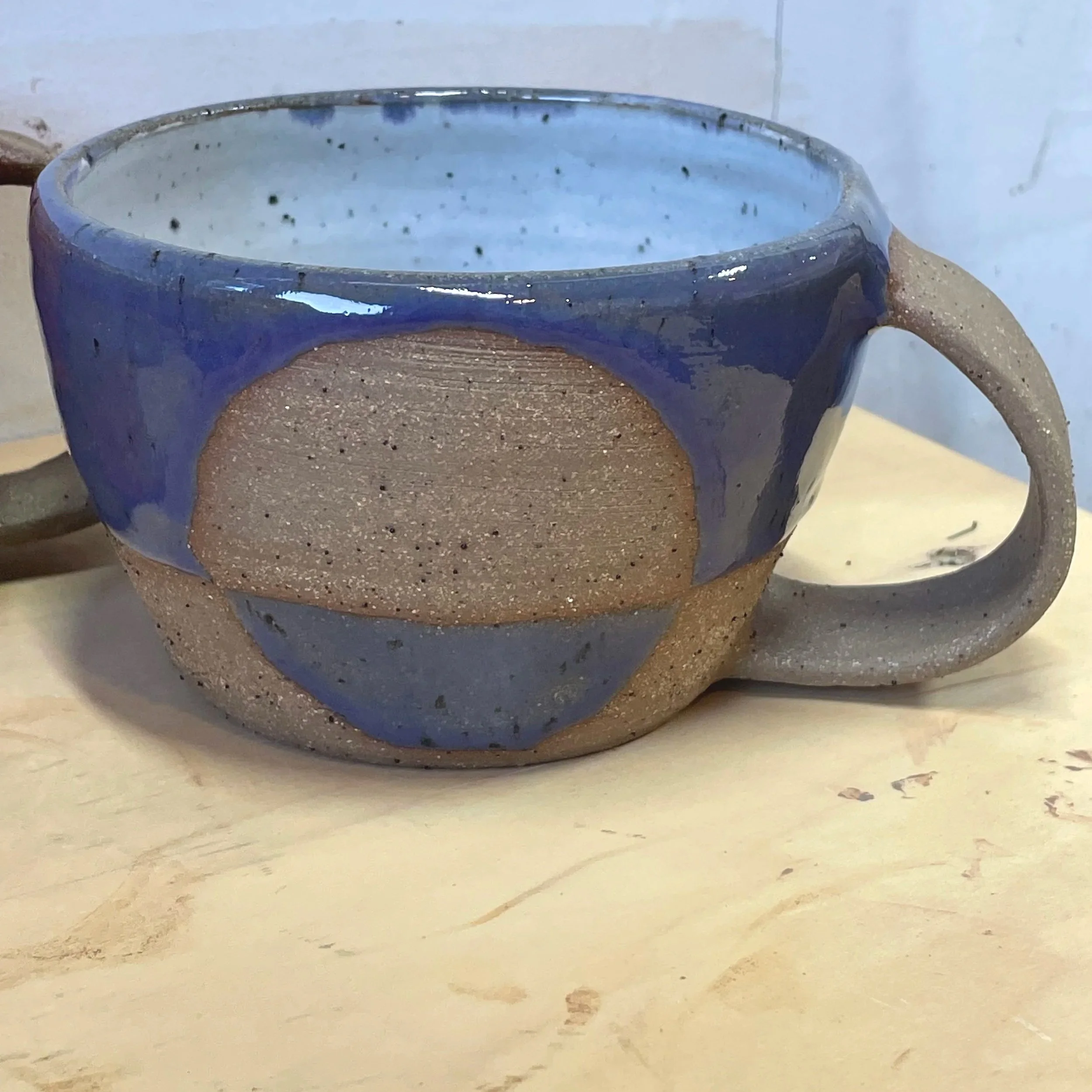 Handmade wheel thrown gloss purple glaze with half-circle on brown clay with speckles mug modern design stoneware mid century modern