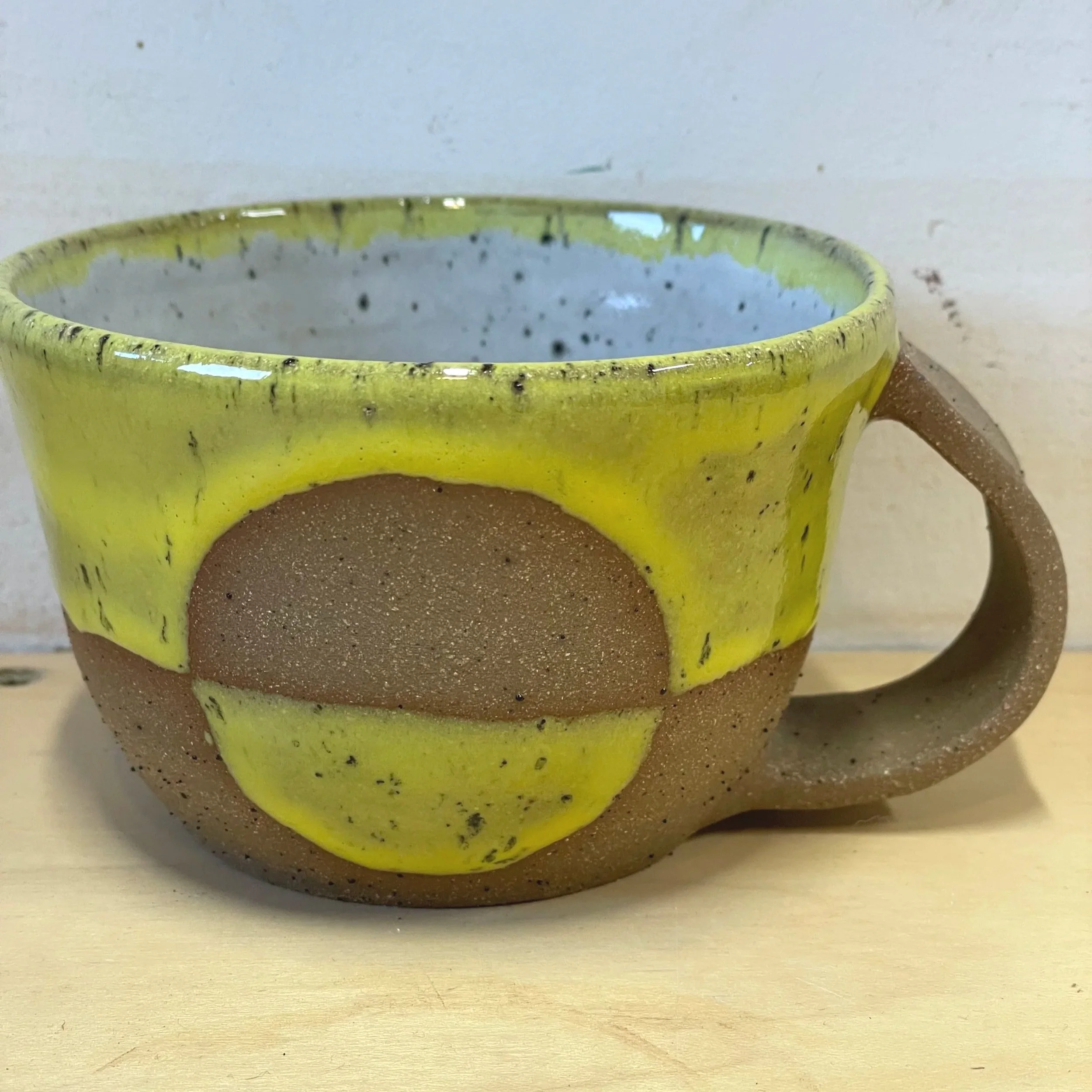Handmade wheel thrown gloss yellow glaze with half-circle on brown clay with speckles mug modern design stoneware mid century modern