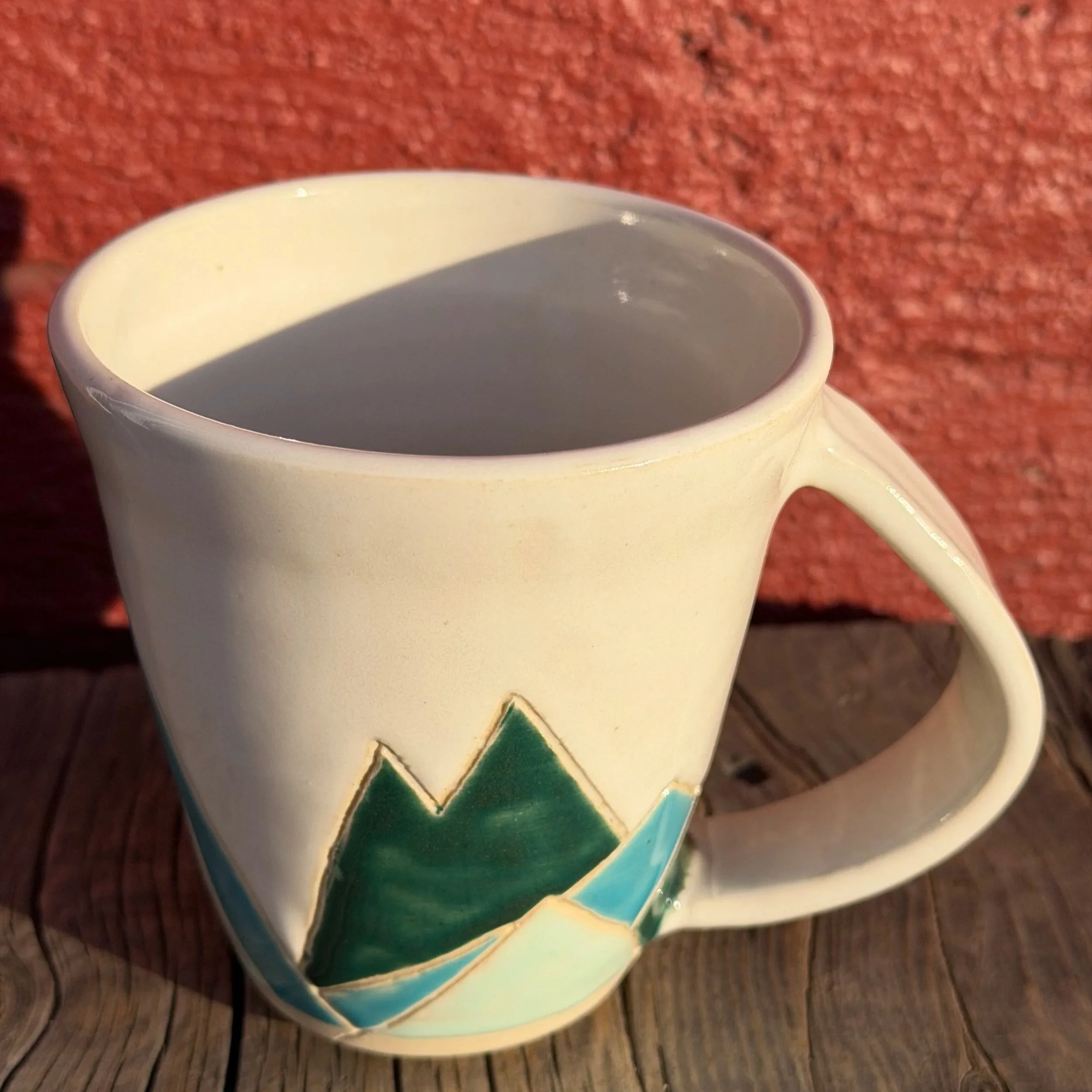 Handmade wheel thrown multi colored mountains on white clay mug modern design stoneware