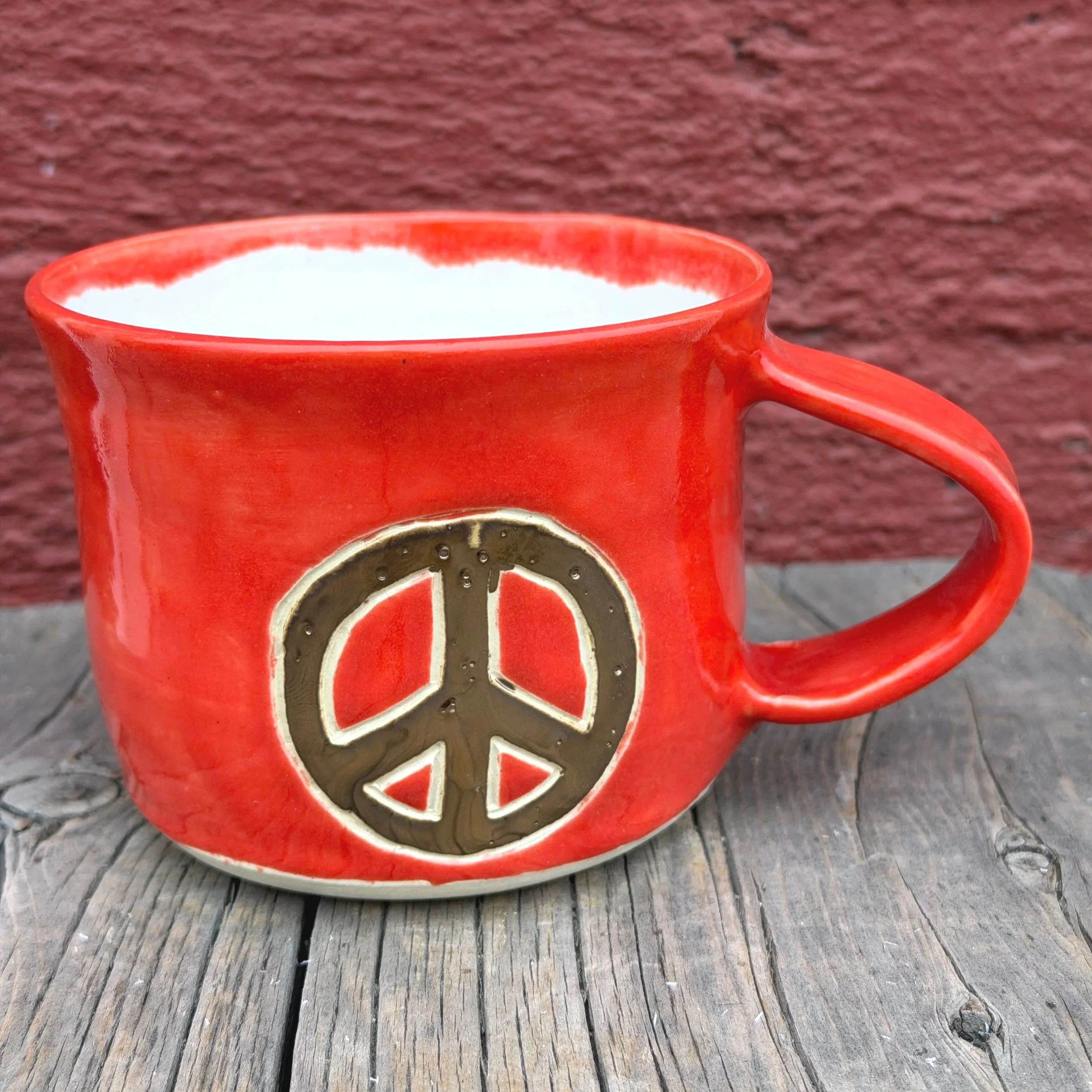 Handmade wheel thrown gold peace sign with red gloss glaze on white clay mug modern design stoneware
