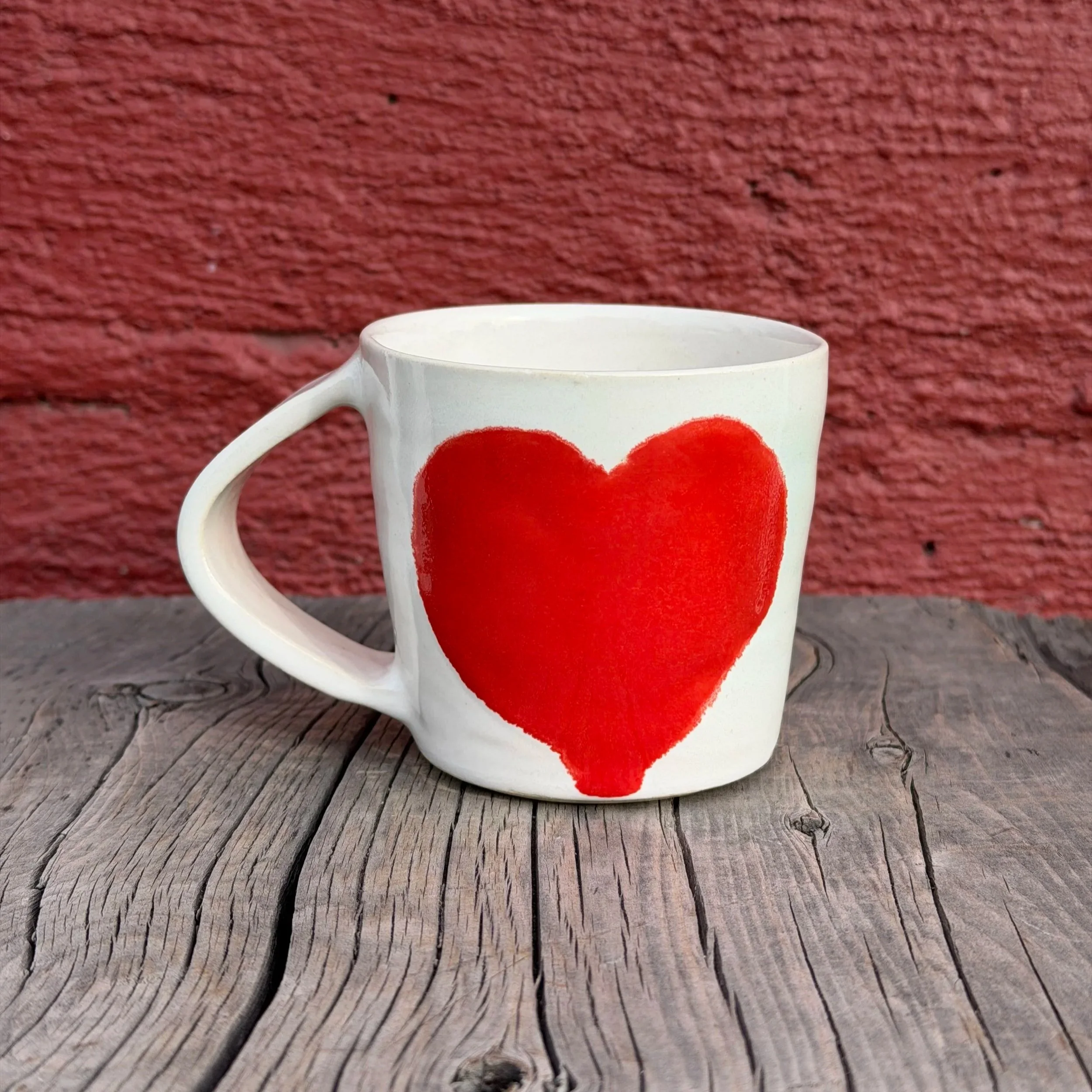 Handmade wheel thrown heart with red gloss glaze on white clay mug modern design stoneware