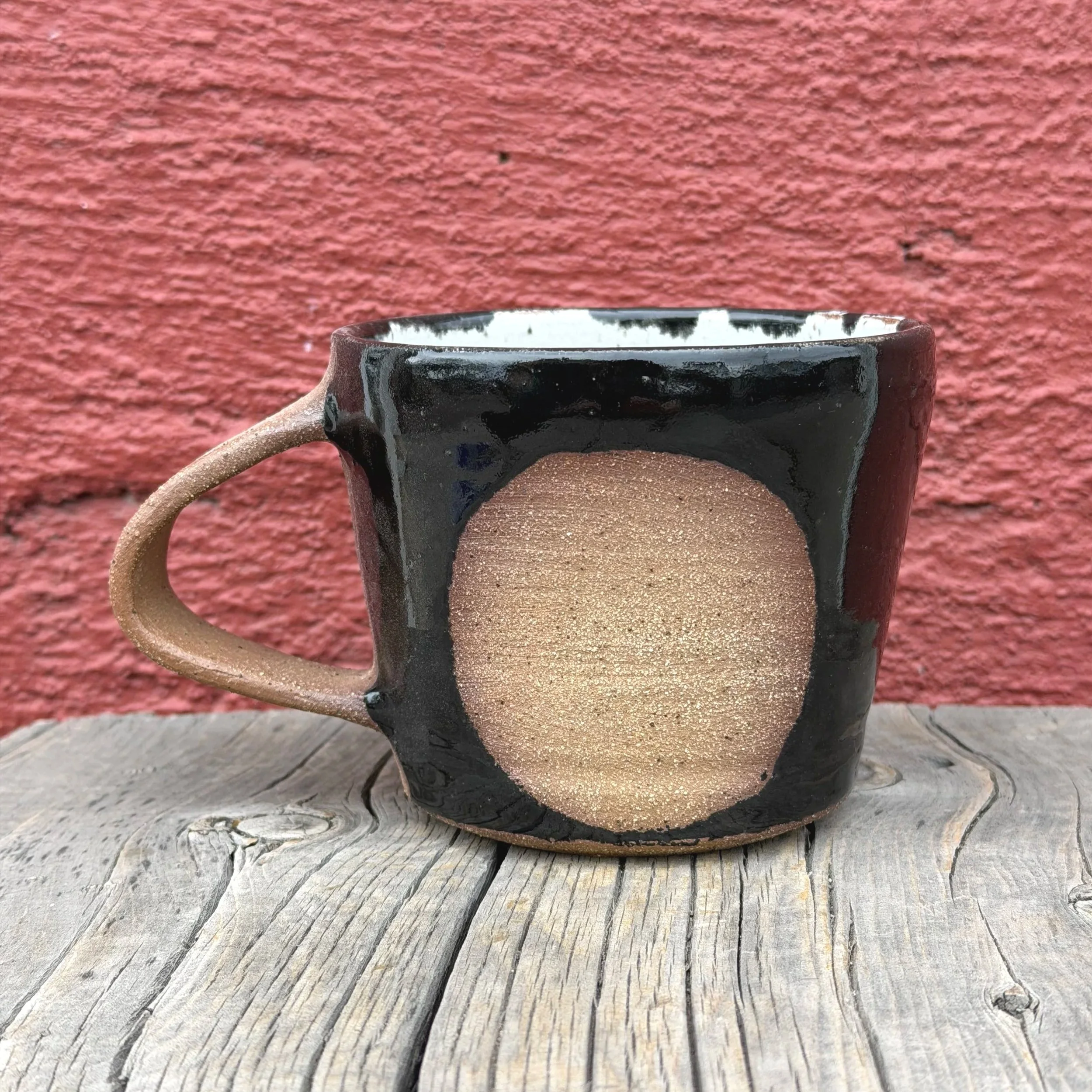 Handmade wheel thrown black gloss glaze with circle on brown clay with speckles mug modern design stoneware mid century modern