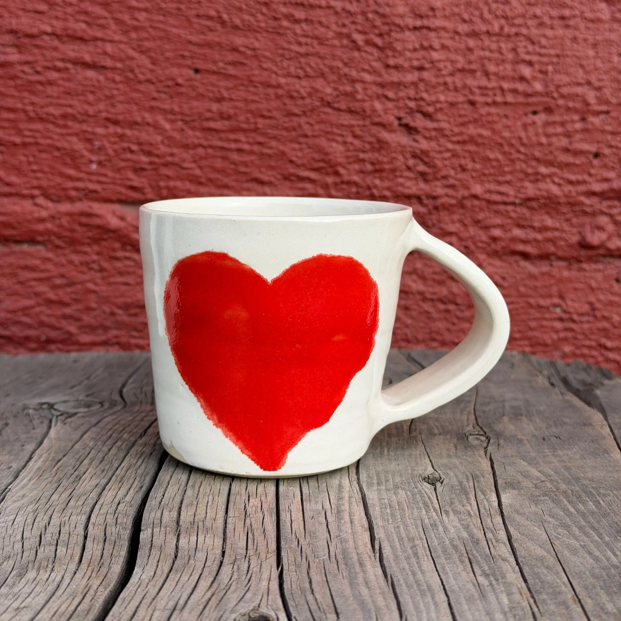 Handmade wheel thrown heart with red gloss glaze on white clay mug modern design stoneware