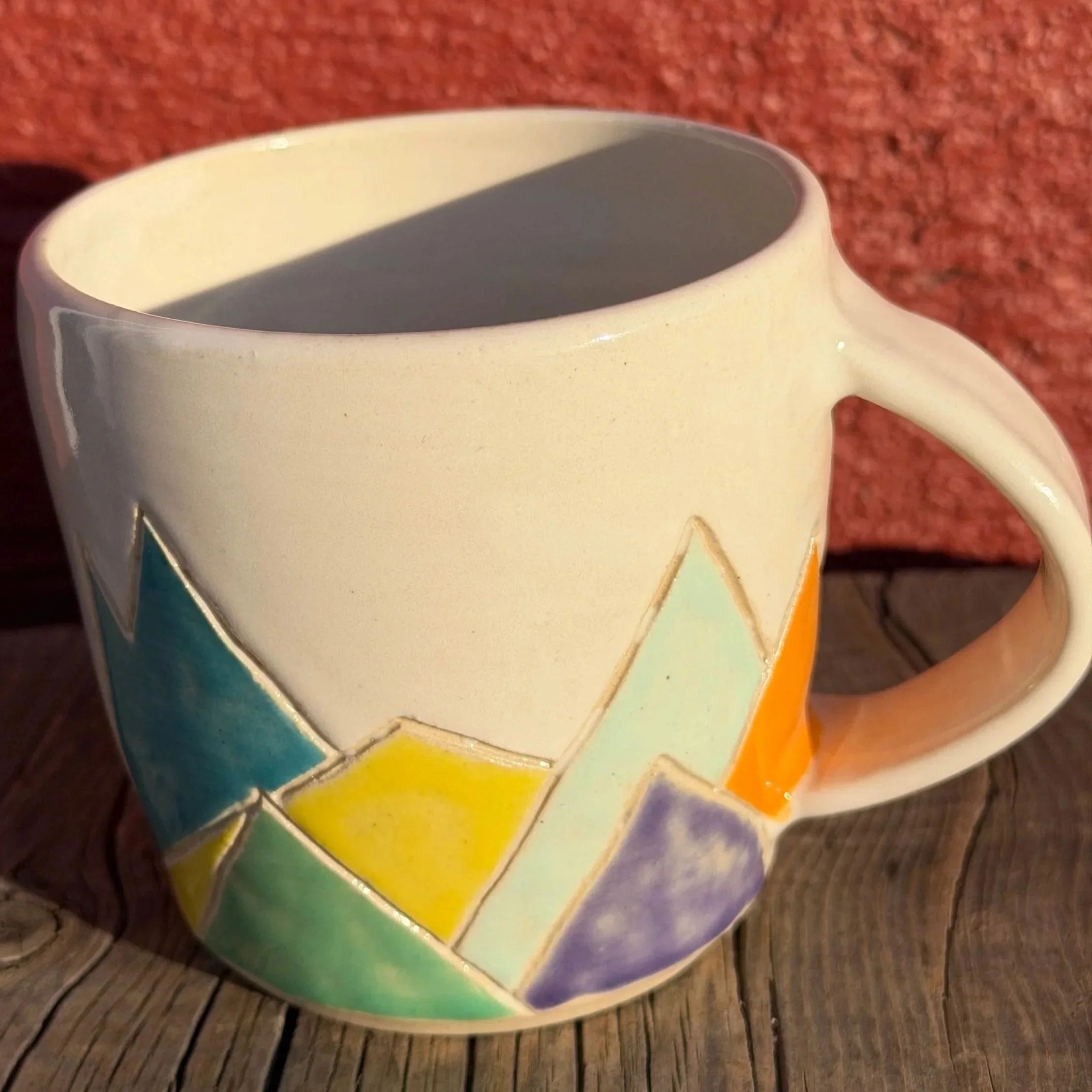 Handmade wheel thrown multi colored mountains on white clay mug modern design stoneware