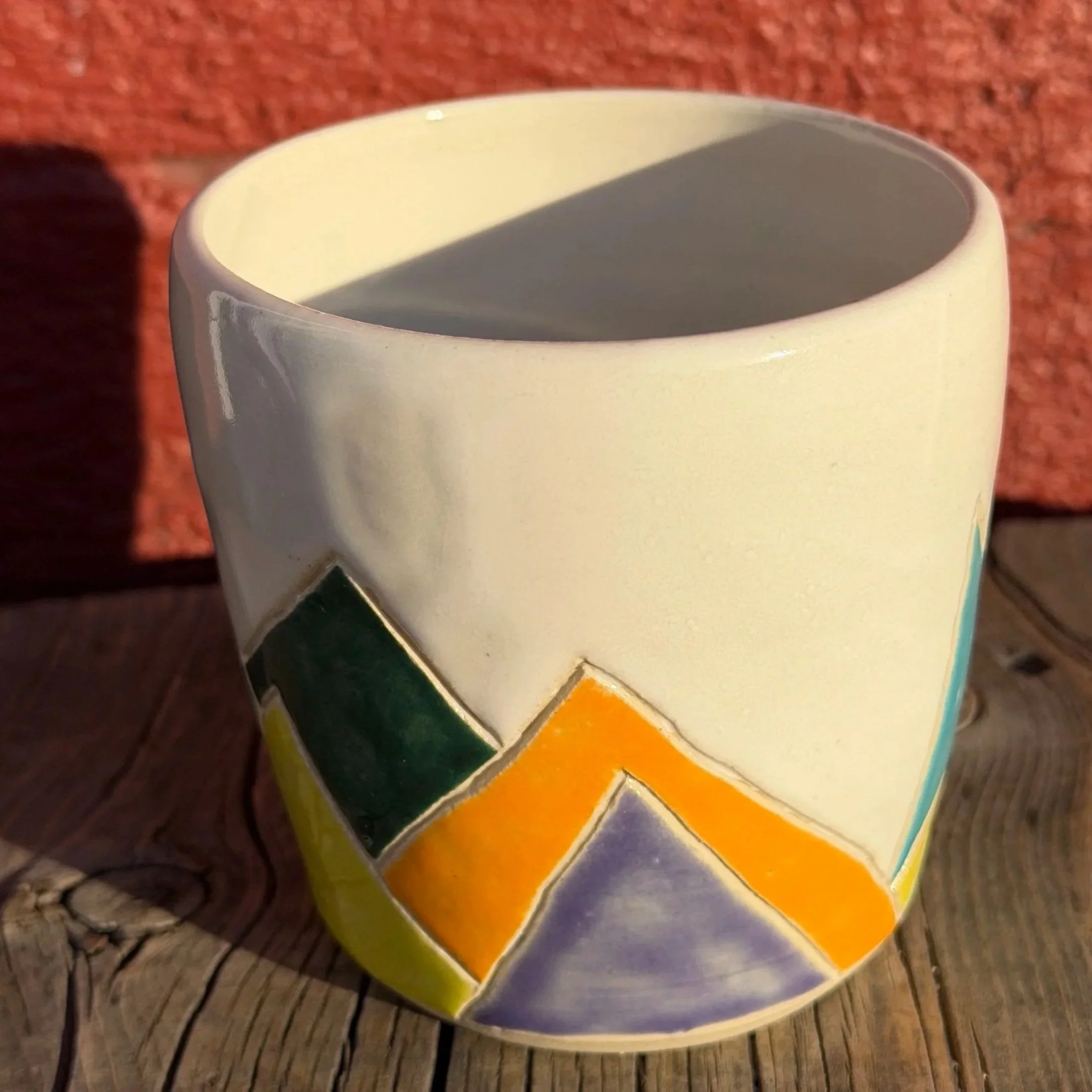 Handmade wheel thrown multi colored mountains on white clay mug modern design stoneware