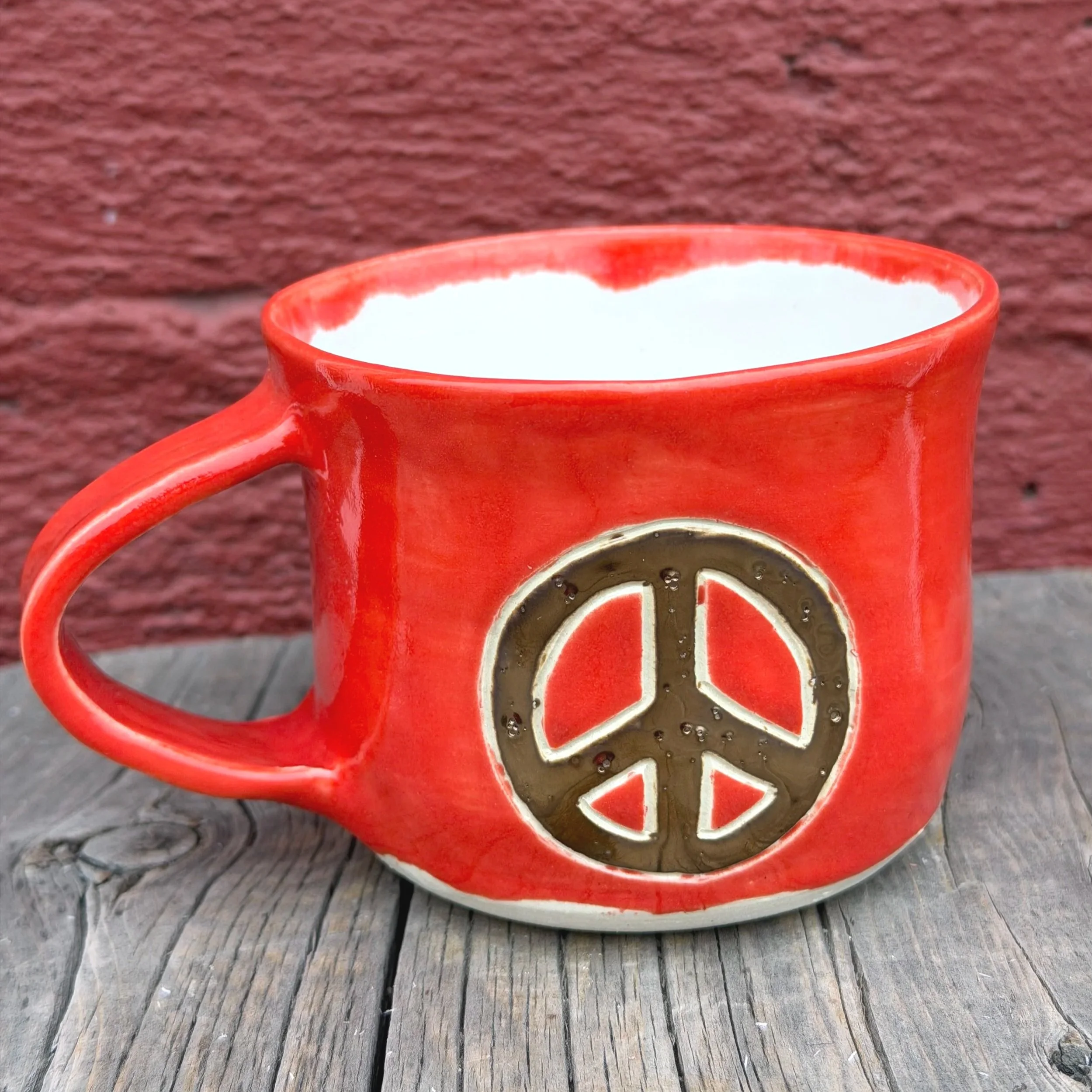 Handmade wheel thrown gold peace sign with red gloss glaze on white clay mug modern design stoneware