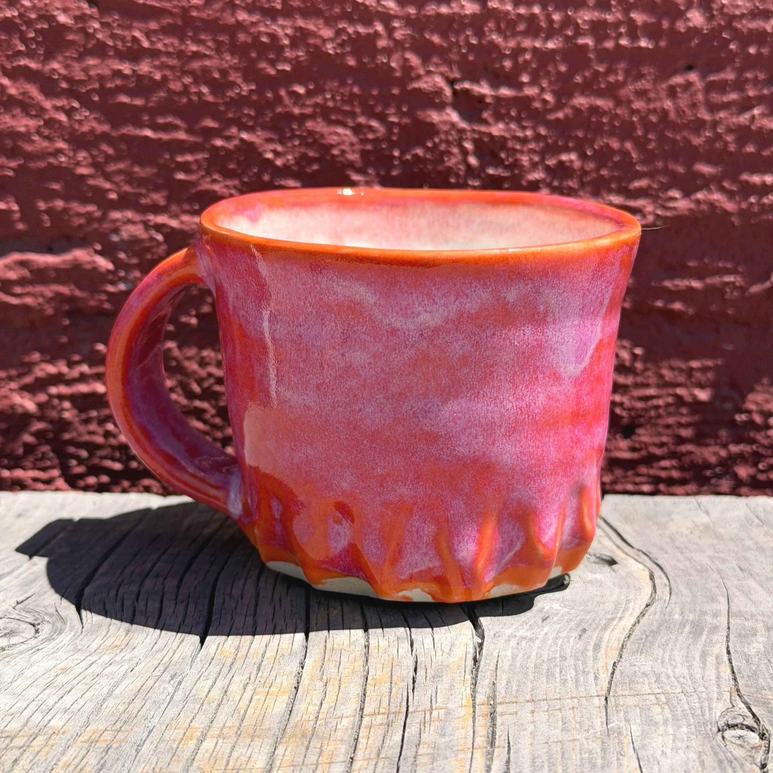Handmade wheel thrown carved bright red and orange gloss glazes on white clay mug modern design stoneware bright